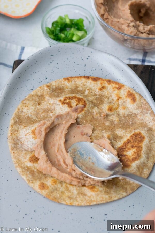 No-Fuss Huevos Rancheros 6 Adding a fried egg to a huevos rancheros tortilla