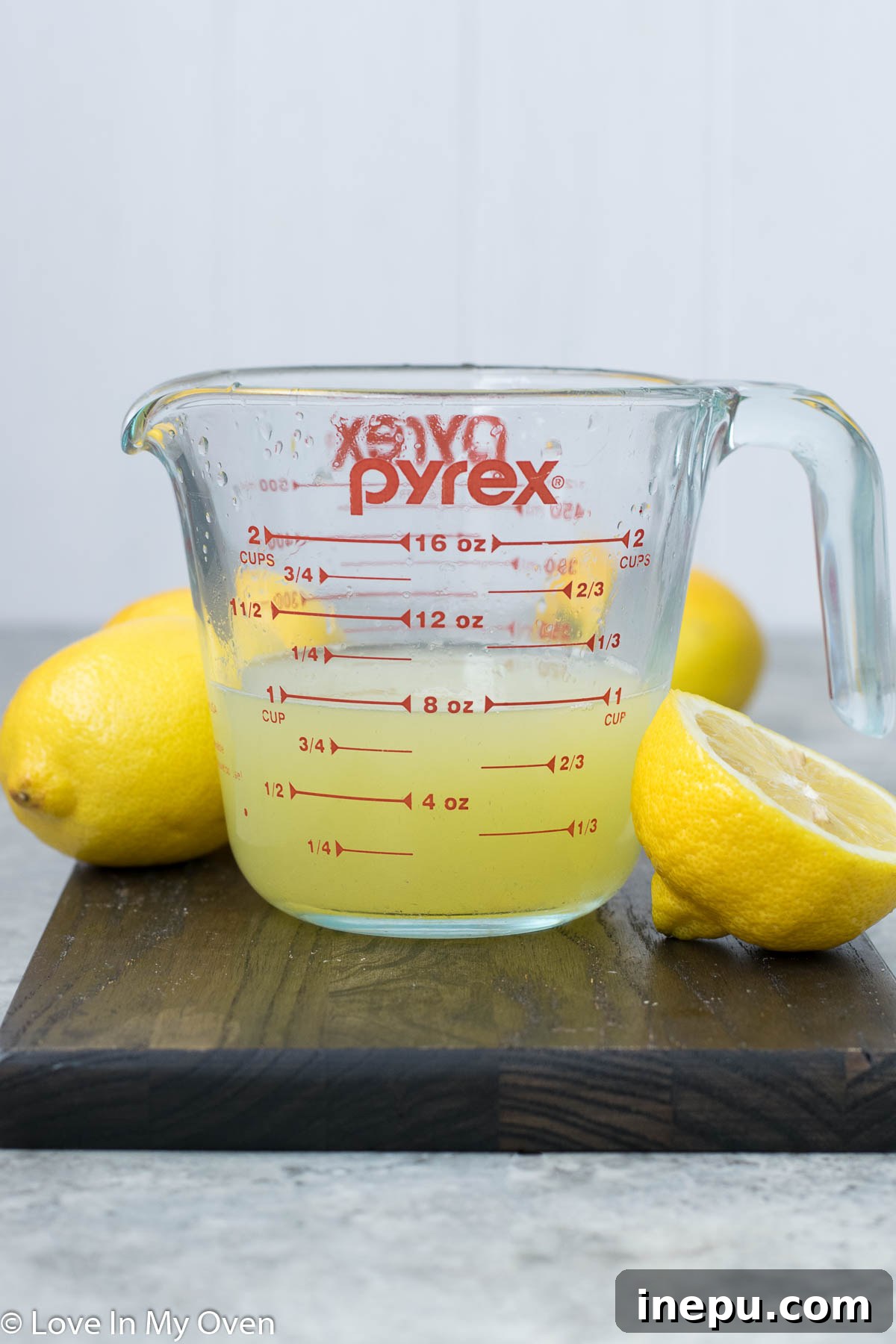 Effortless Honey Lemonade 5 Honey lemonade being poured into a glass with ice and lemon slices
