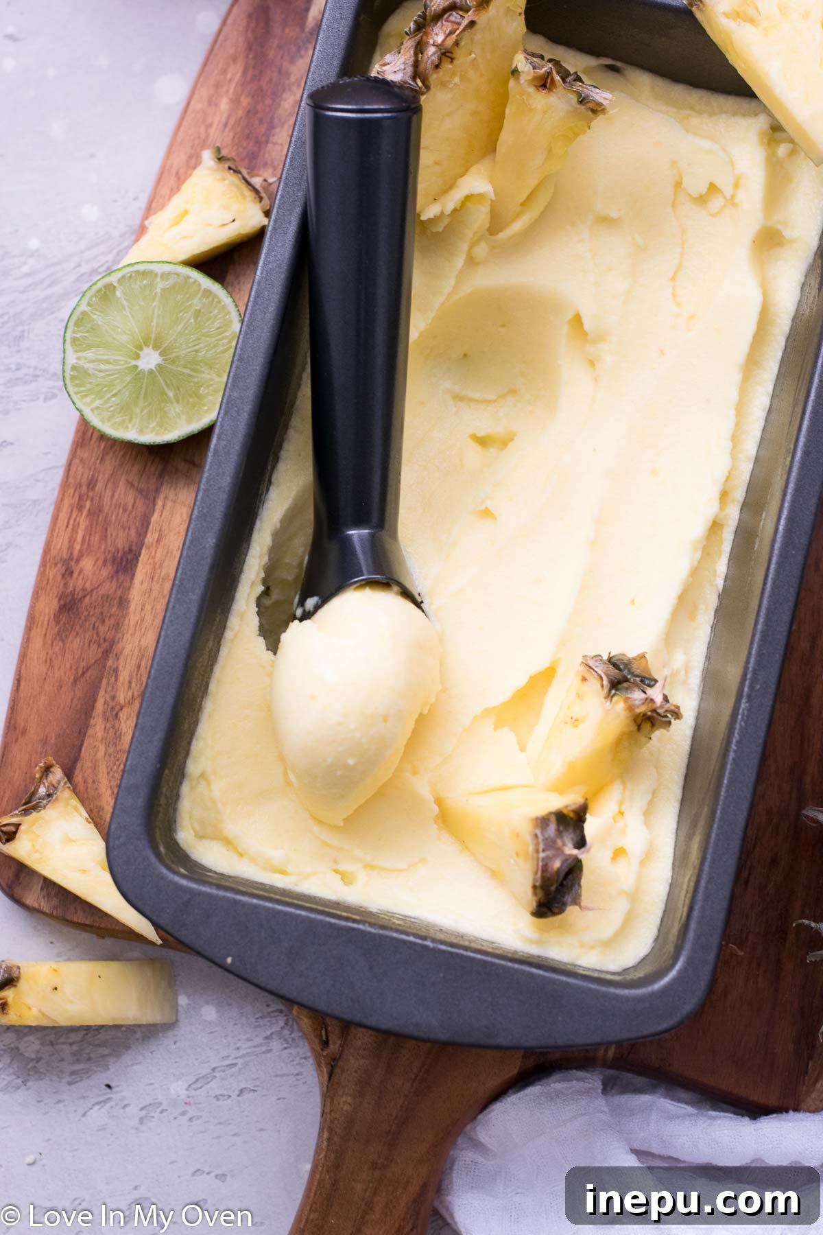 Tropical Pineapple Chill 7 A bowl of creamy pineapple sorbet with a spoon, ready to be eaten.