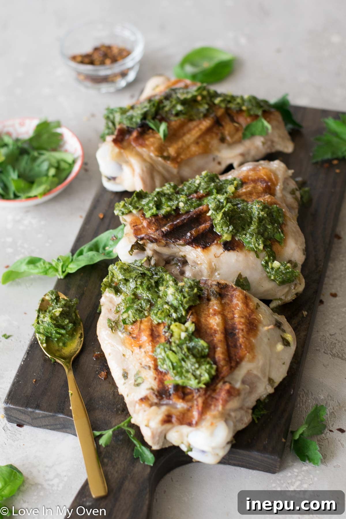 Smoky Turkey Thighs with Vibrant Chimichurri 3 Close-up of grilled turkey thigh on a plate, drizzled with chimichurri sauce.