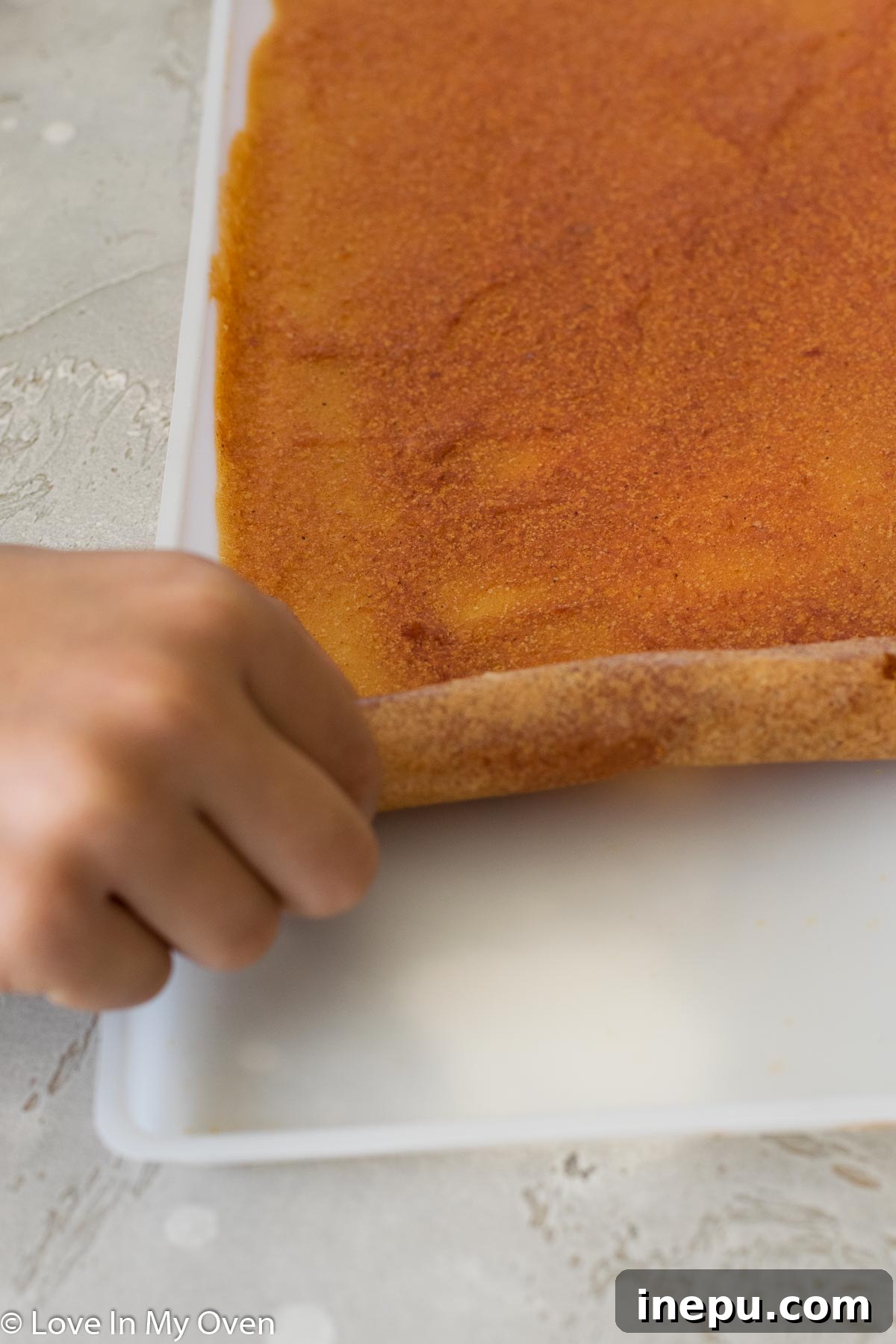 Several rolls of homemade apple fruit leather on a cutting board.