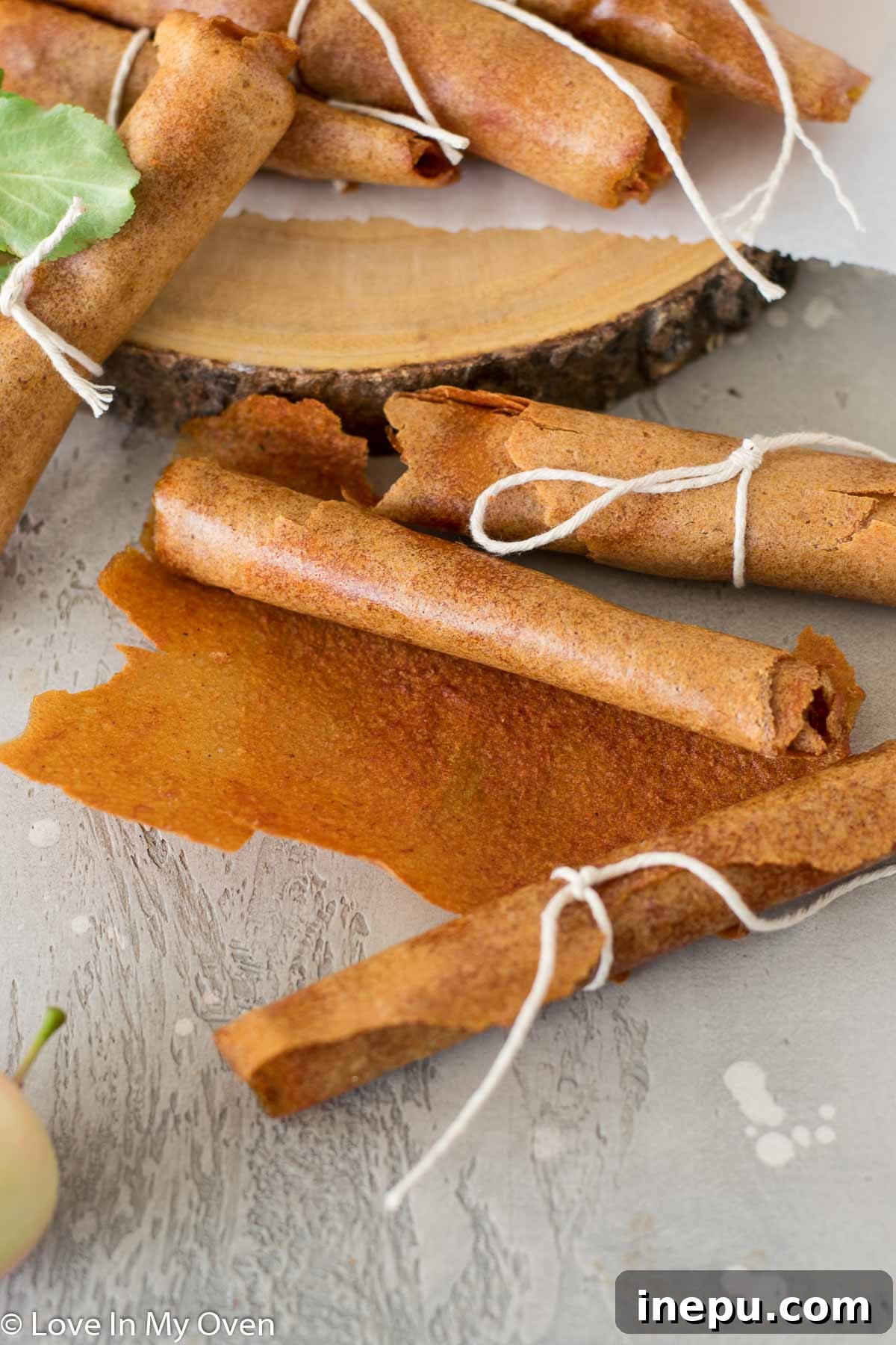 A close-up of a single rolled apple fruit leather, ready for snacking.