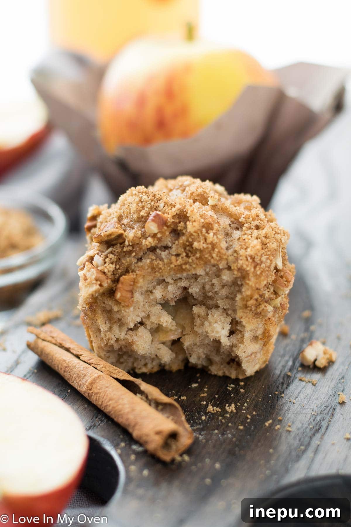 Harvest Spiced Cider Muffins 2 Delicious Apple Cider Muffins with a crumble topping, served on a rustic wooden board.