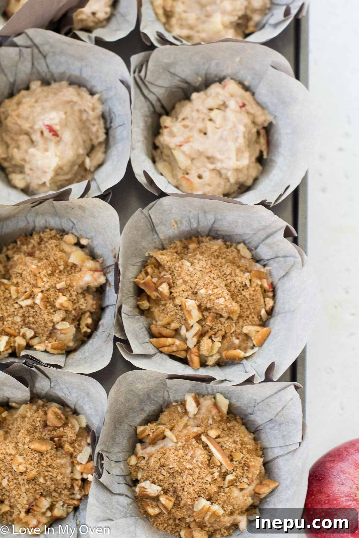 Harvest Spiced Cider Muffins 6 Muffin batter being scooped into paper liners, topped with streusel.
