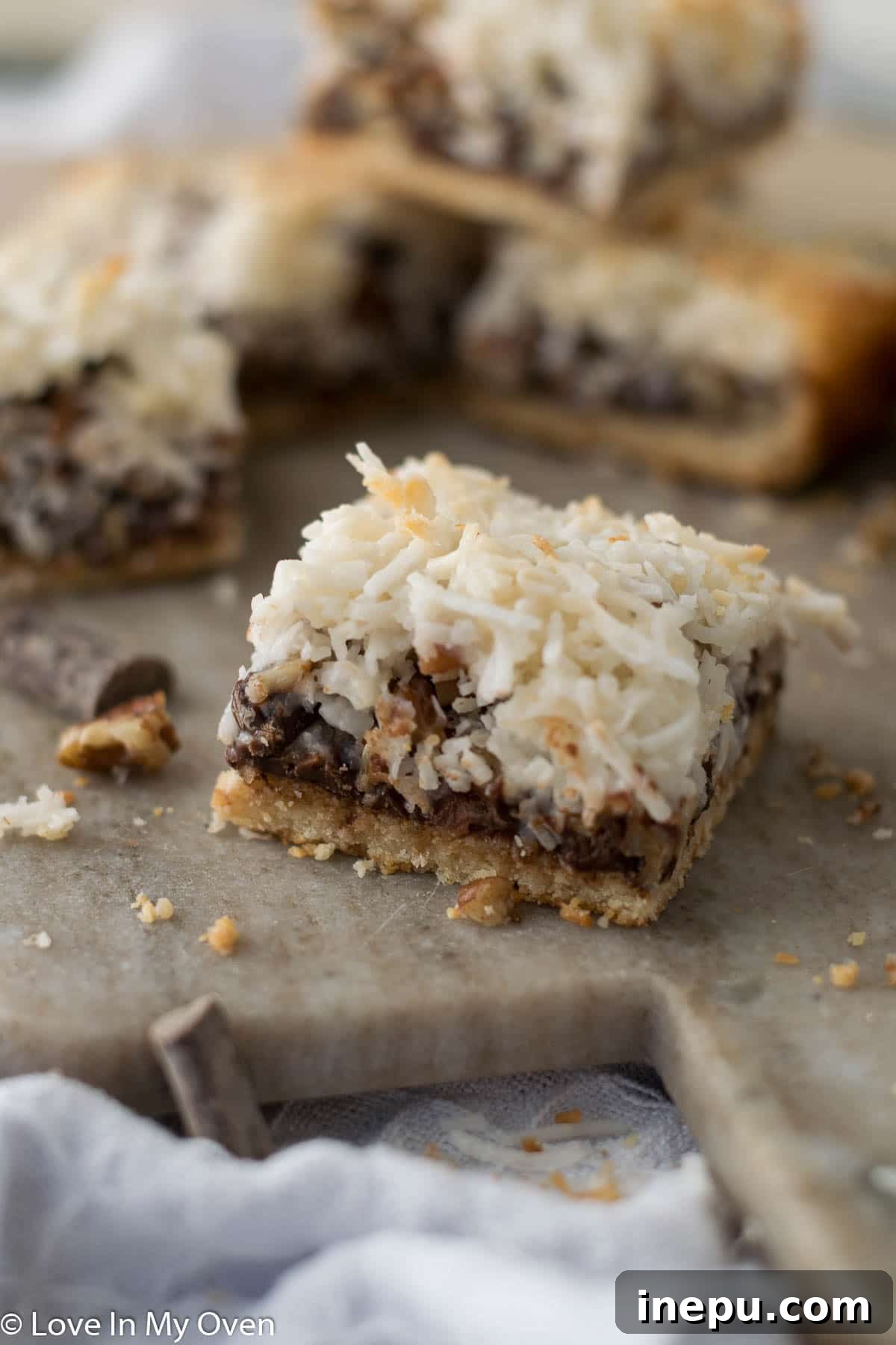 Plant-Based Dream Bars 10 Stack of freshly baked vegan magic bars on a serving plate.