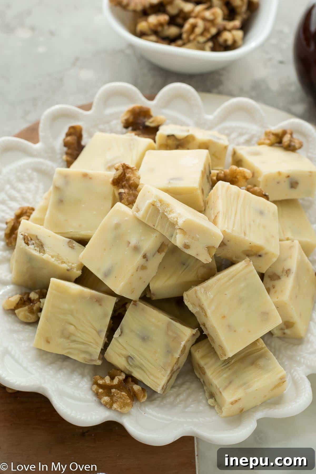A batch of freshly cut maple walnut fudge on a plate, ready to be enjoyed.