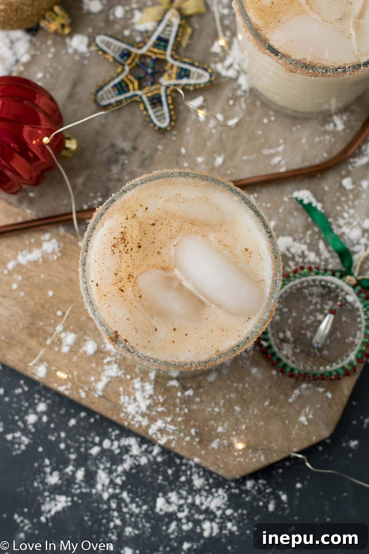 Velvet Vodka Nog 4 Hands holding a Vodka Eggnog Cocktail in a snowy setting