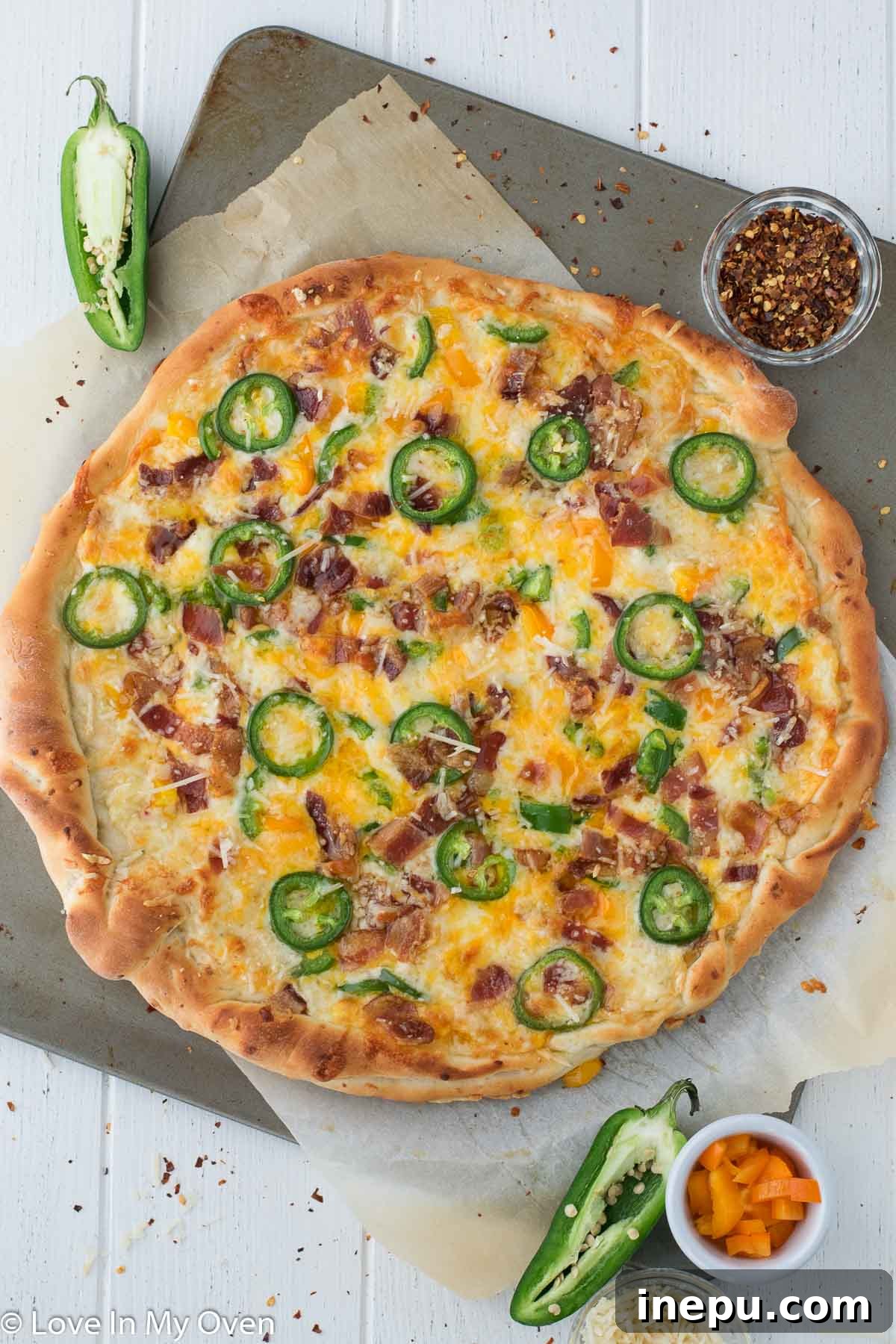 Close-up of a slice of Jalapeño Popper Pizza with creamy cheese and crispy bacon