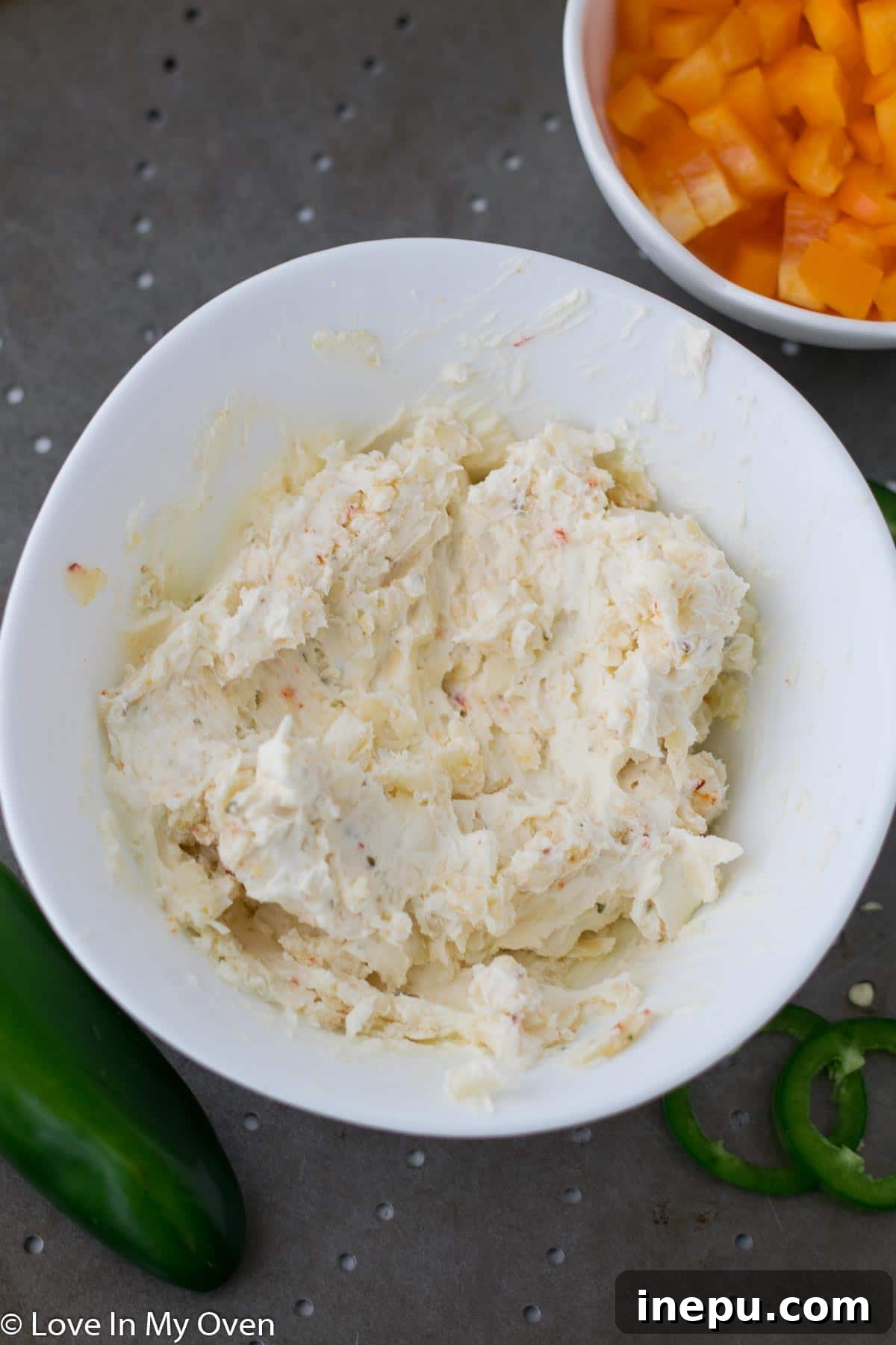 Spreading cream cheese mixture on pizza dough