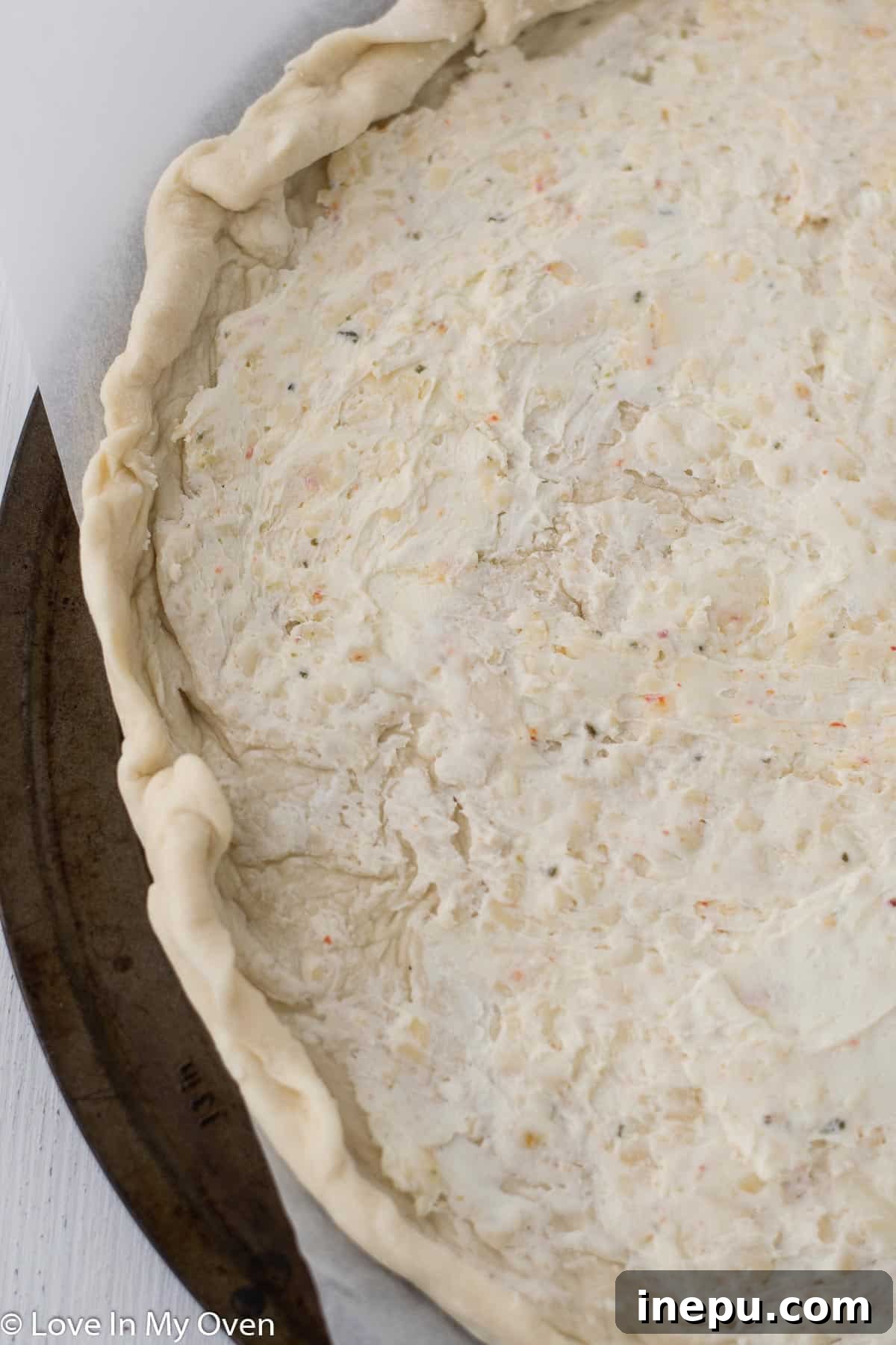 Adding shredded cheese and other toppings to the pizza