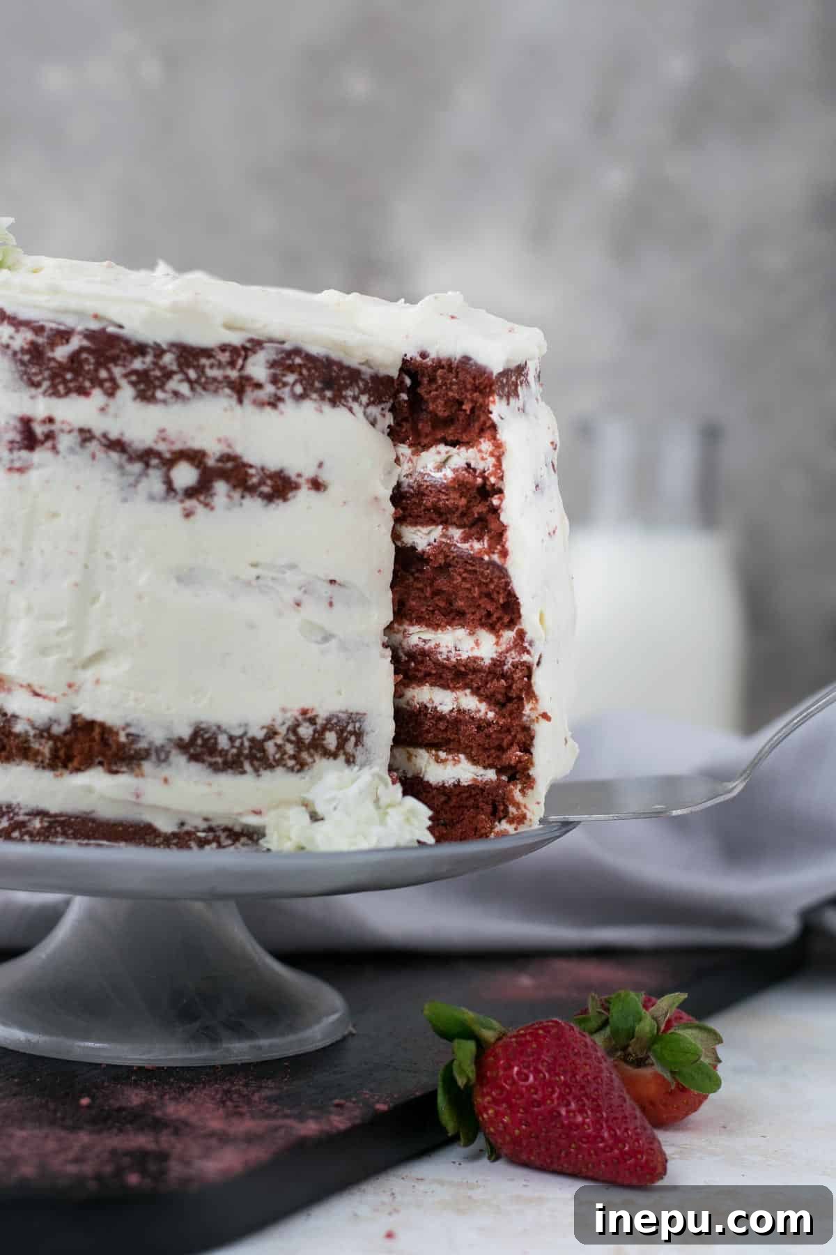 Top-down view of a mini red velvet cake with decorative frosting and crumbs.