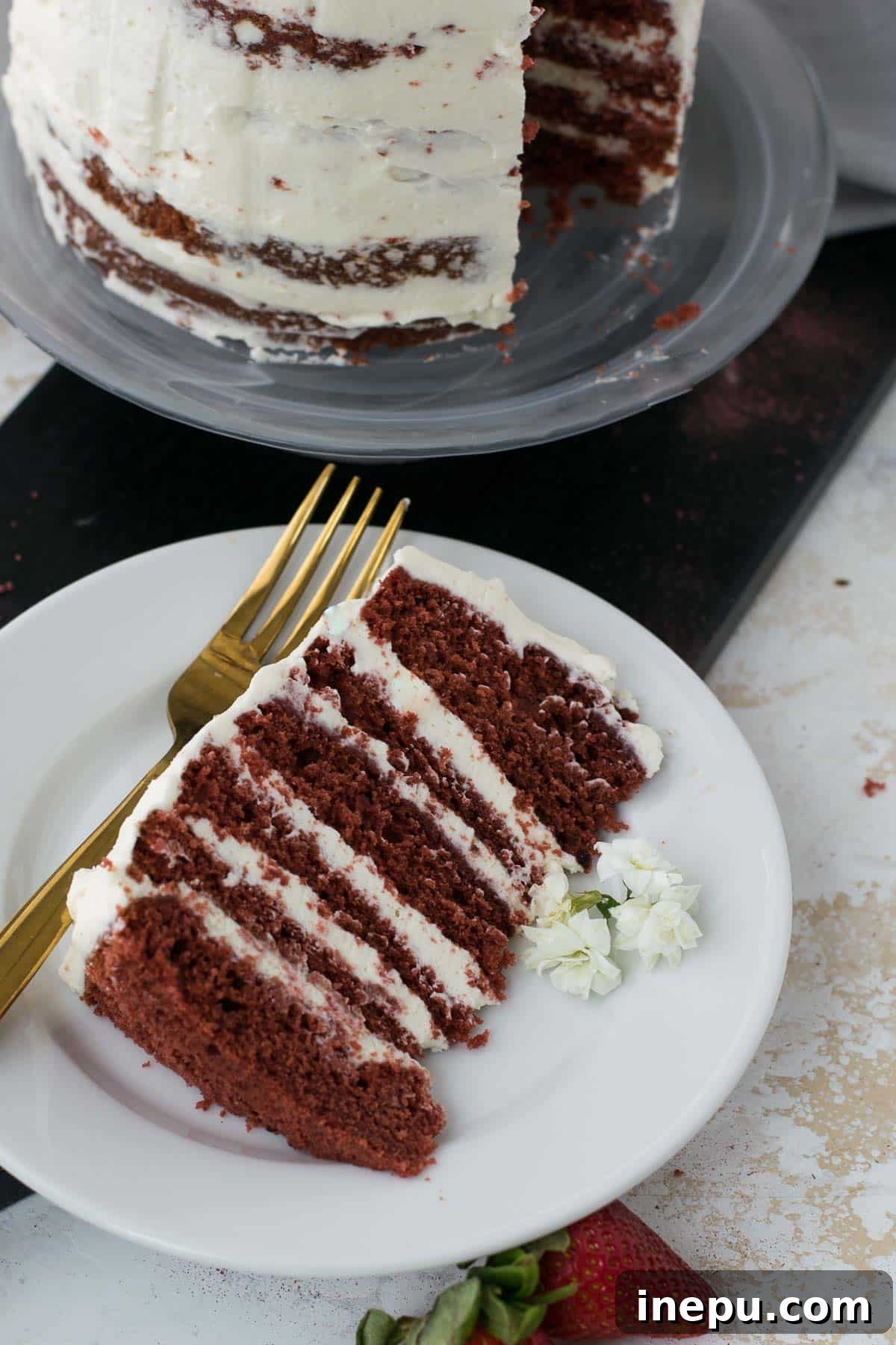 Slice of mini red velvet cake showing rich red layers and white frosting.