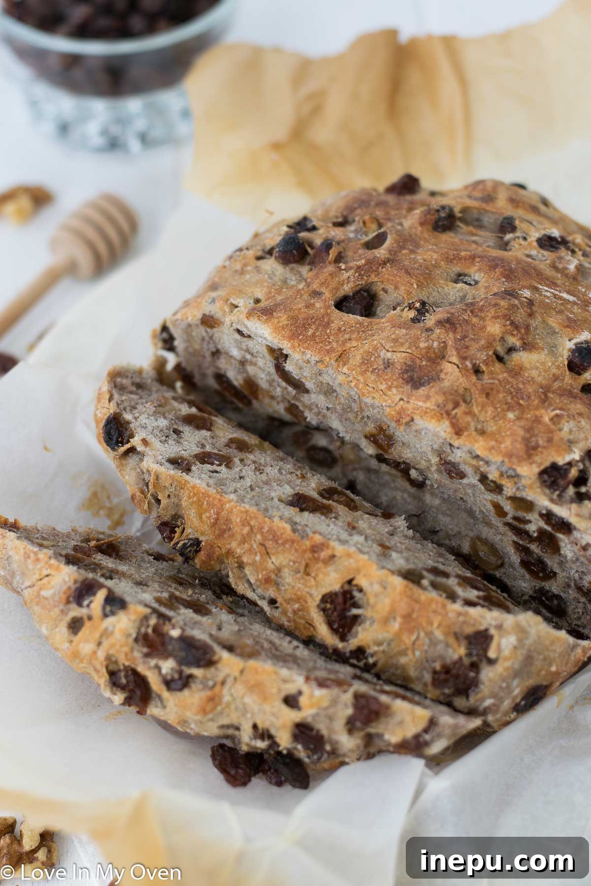 Interior view of sliced cinnamon raisin walnut bread showing its soft texture and even distribution of ingredients.