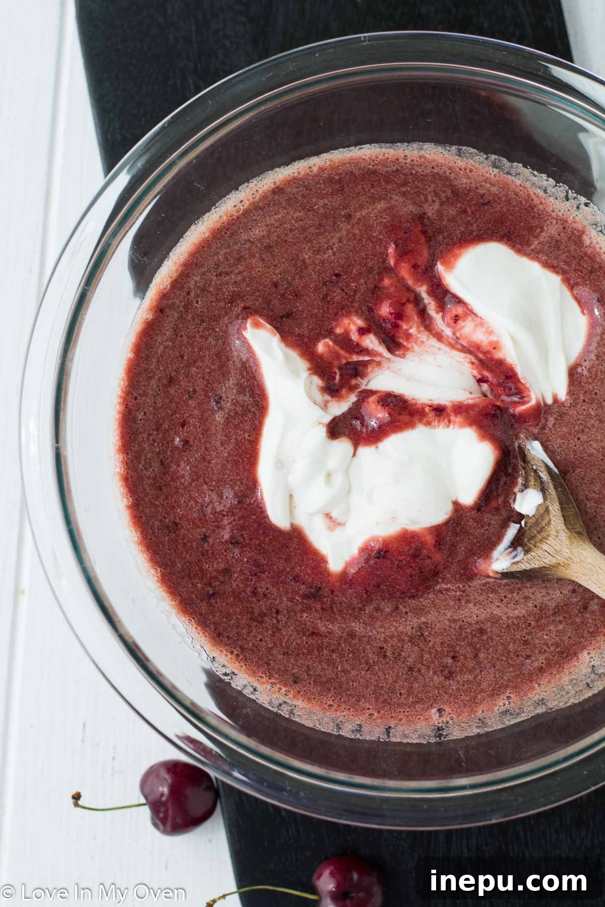 Mixing cherry puree with Greek yogurt for a creamy popsicle base.