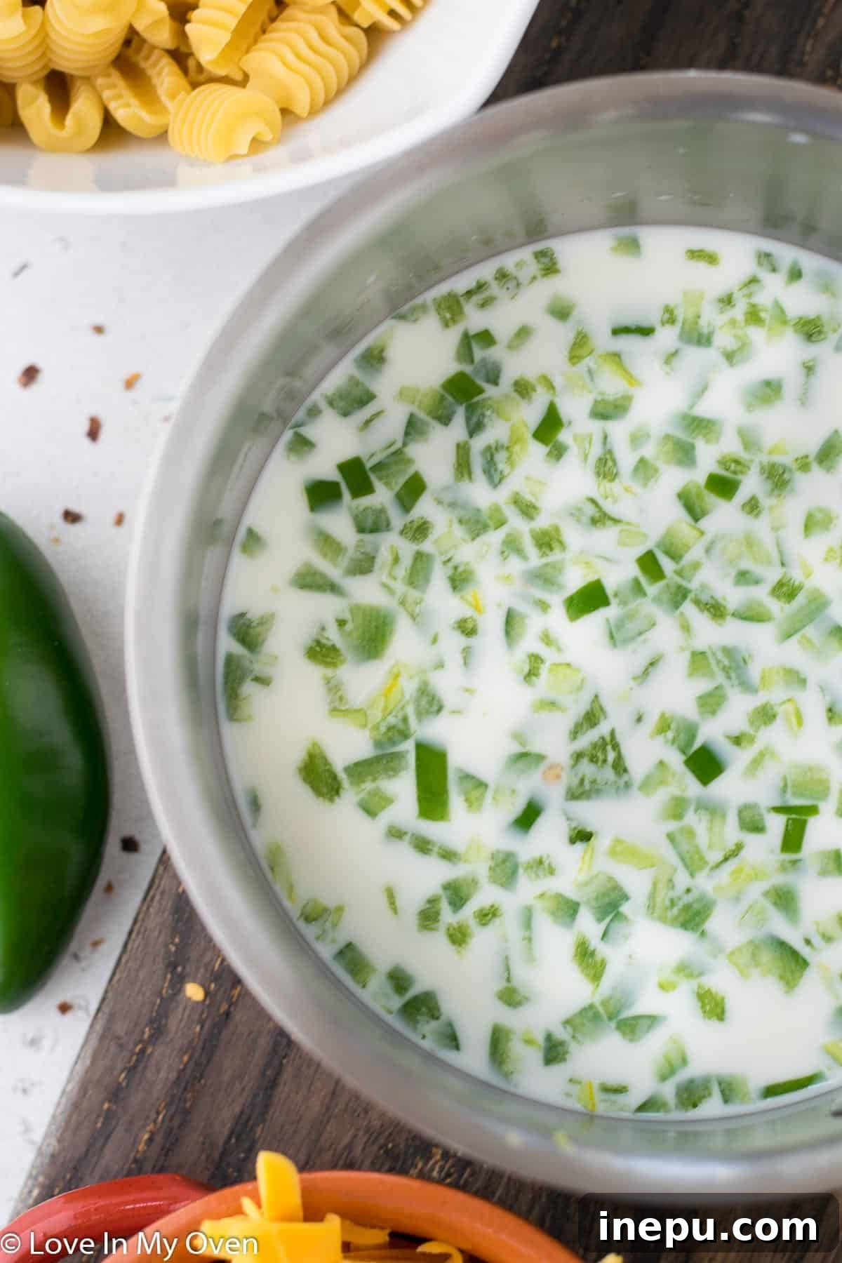 Jalapeno Zing Mac 4 Sliced jalapenos steeping in milk on a stovetop