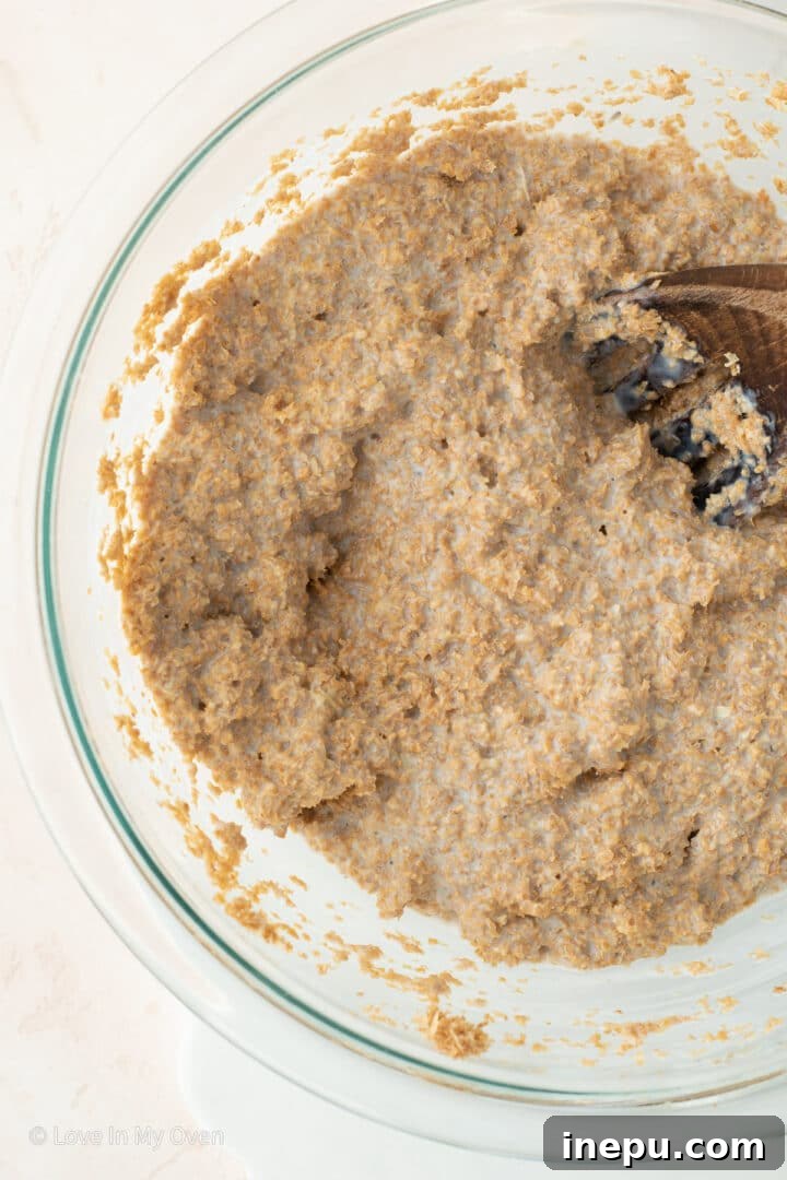 Muffin batter scooped into a pan with coarse sugar on top