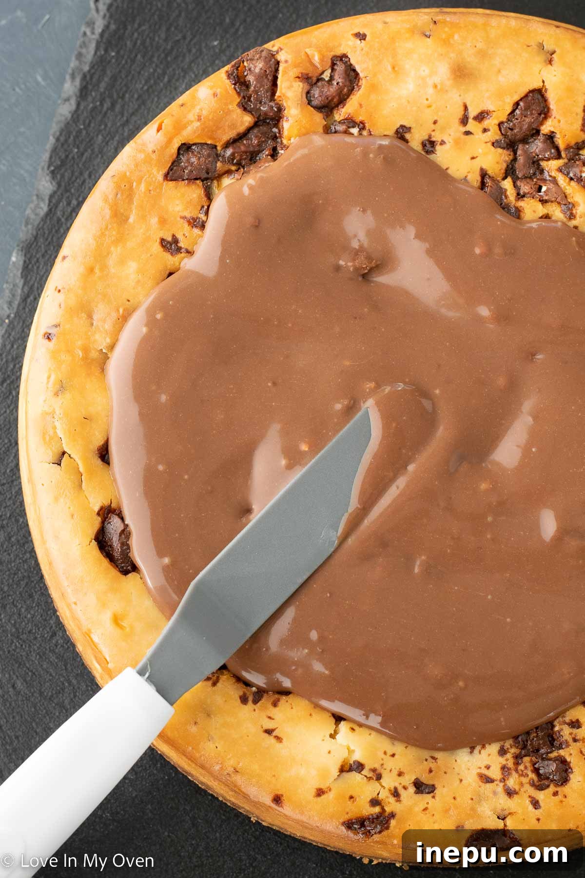 Decadent Toblerone Cheesecake 8 Toblerone ganache being poured over cheesecake.