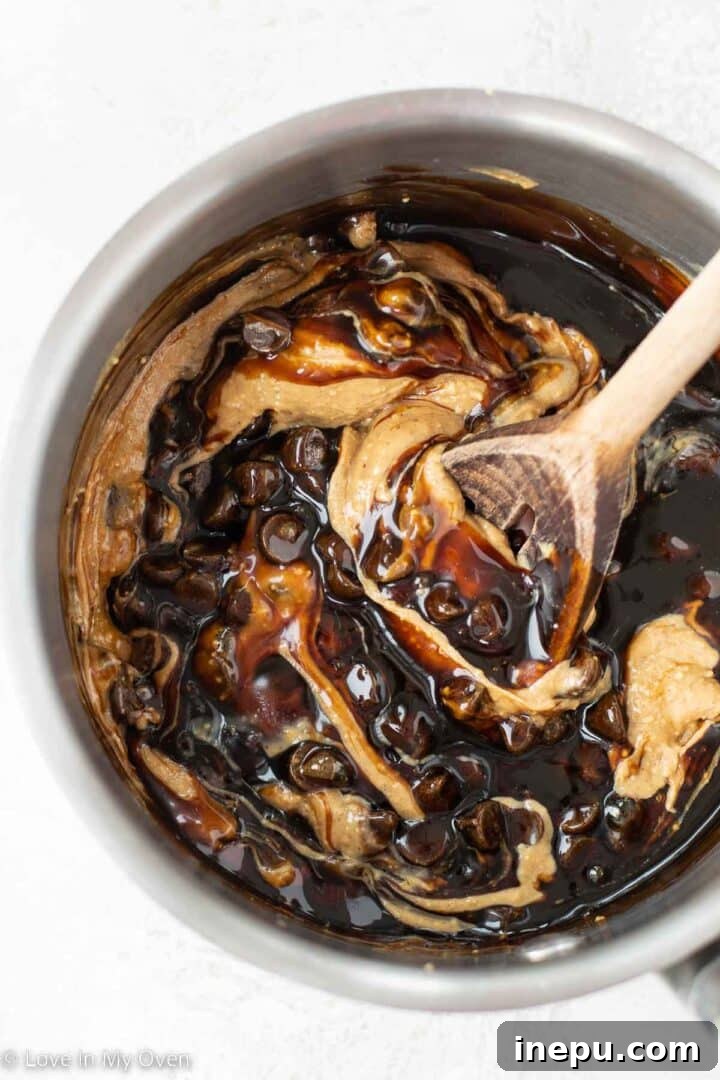 Nourishing Homemade Energy Bars 4 Melting chocolate chips, date syrup, and peanut butter for Eat-more bars