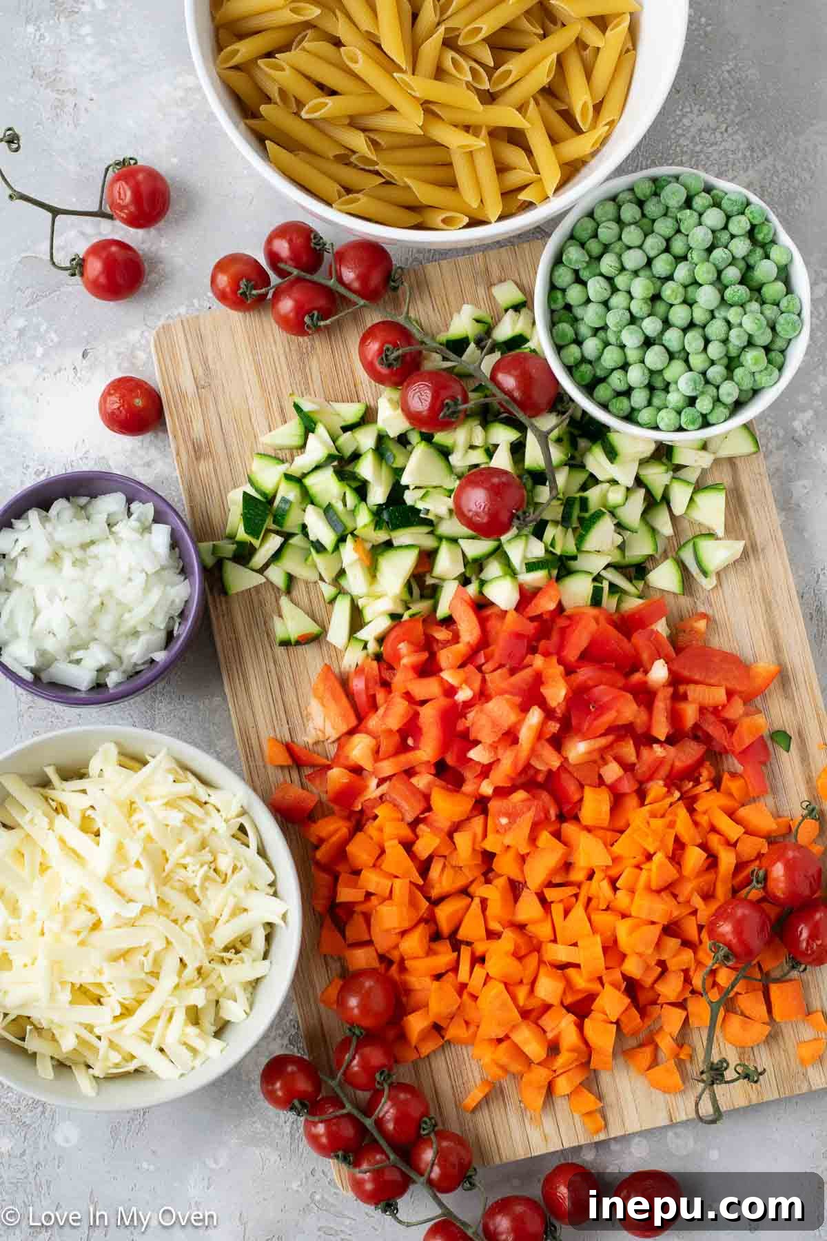 Cheesy Baked Veggie Pasta 3 Freshly diced vegetables for the pasta bake, including onion, garlic, bell pepper, zucchini, and carrots