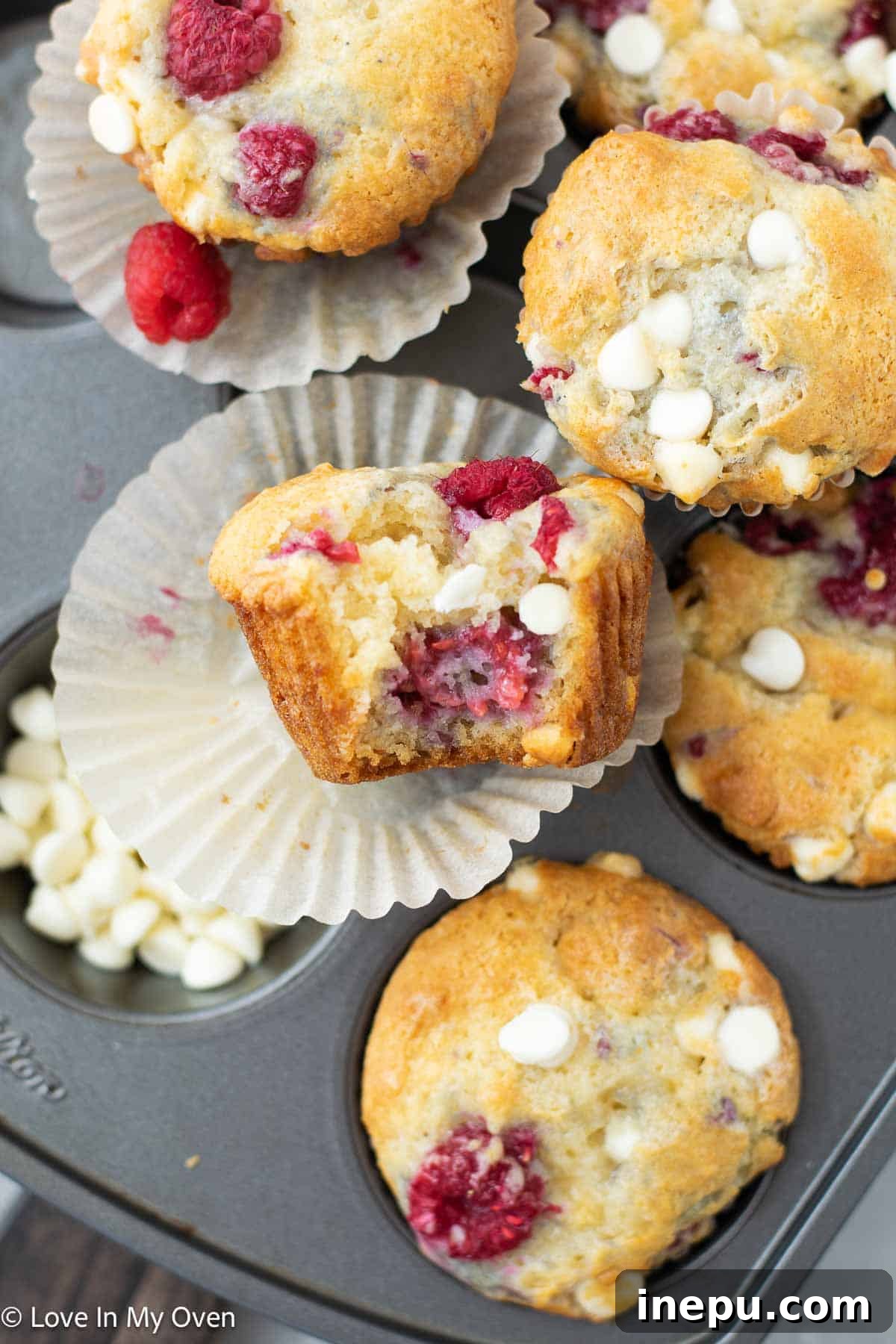 Luscious Raspberry White Chocolate Muffins 8 A stack of freshly baked Raspberry White Chocolate Muffins on a plate, ready to be served