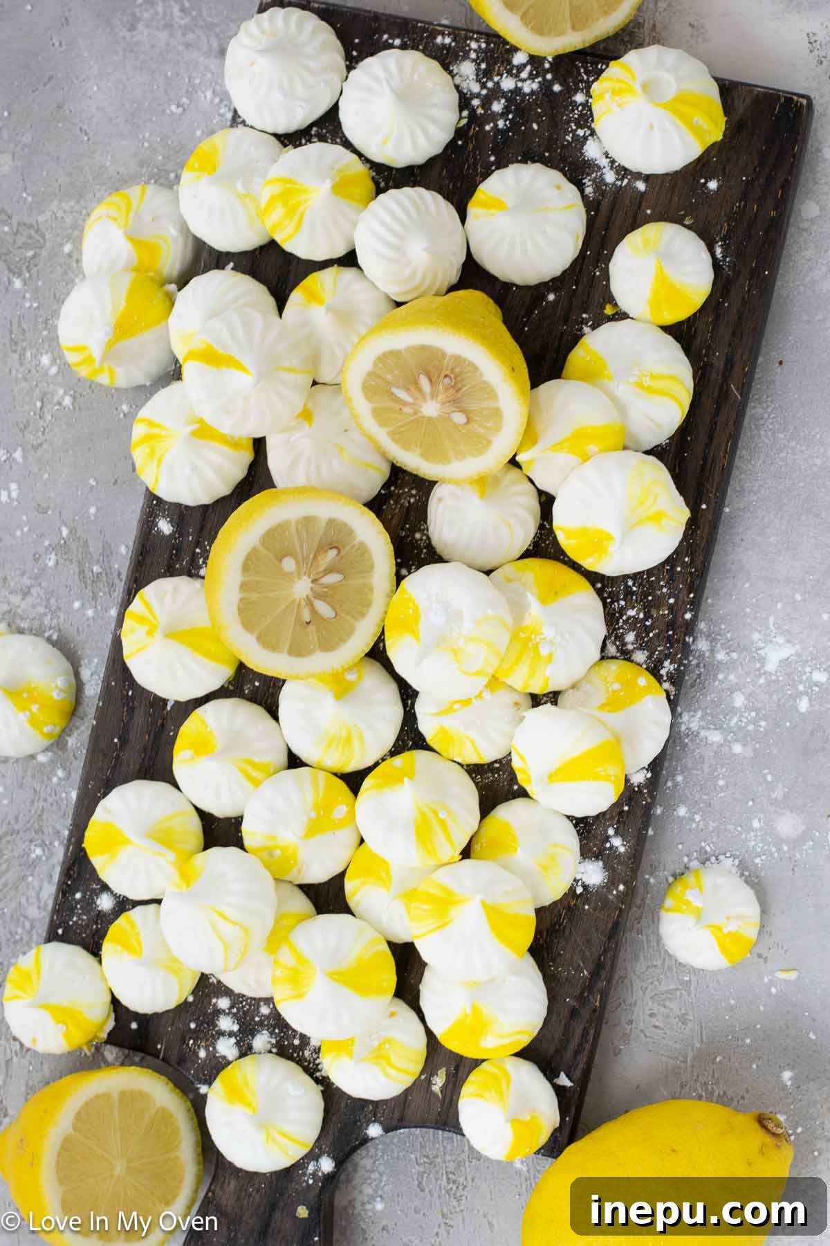 Delicate lemon meringue cookies perfectly piped on a baking sheet, ready to melt in your mouth.