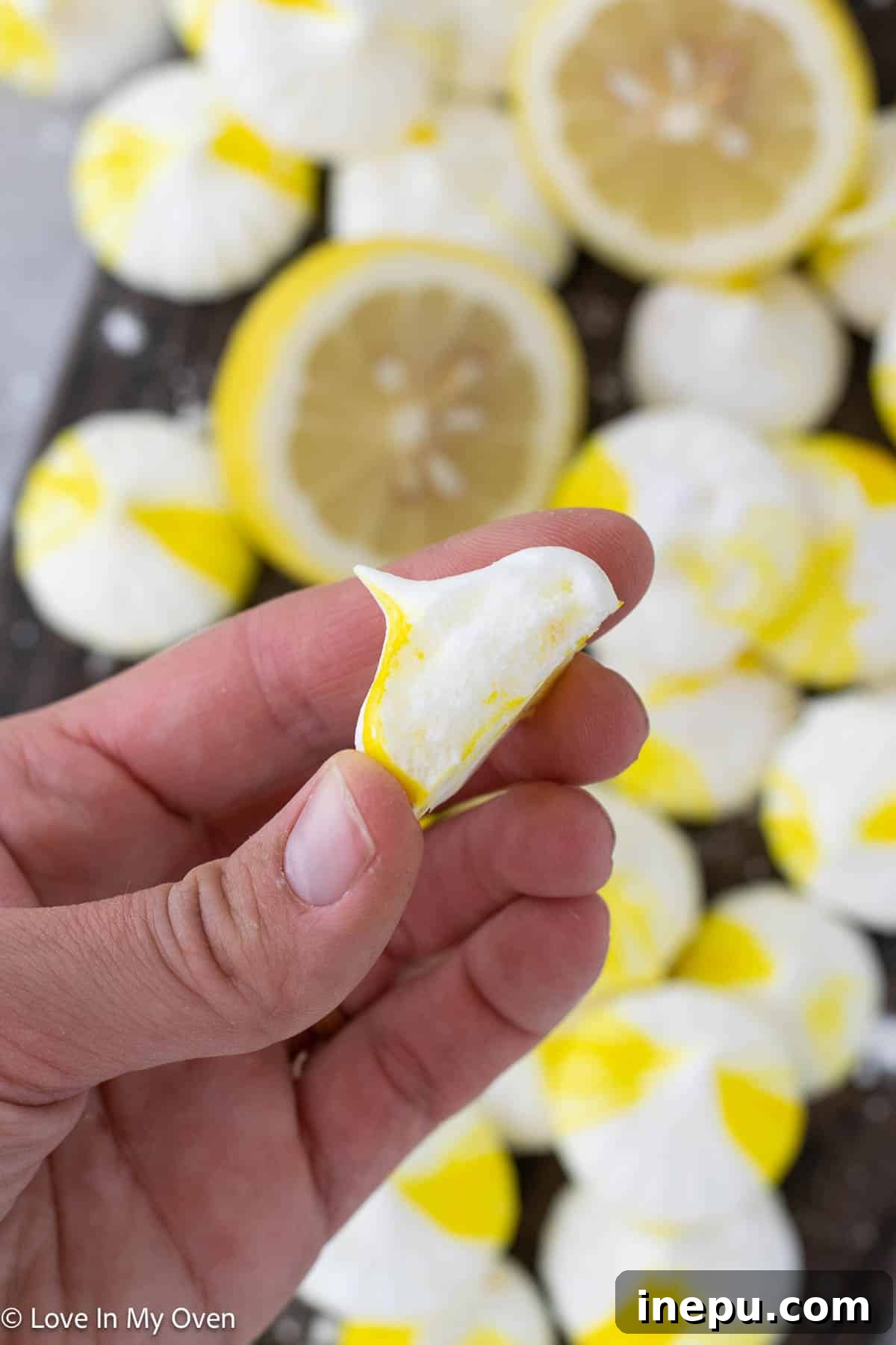 Two lemon meringue cookies resting on a white surface, showcasing their elegant presentation.