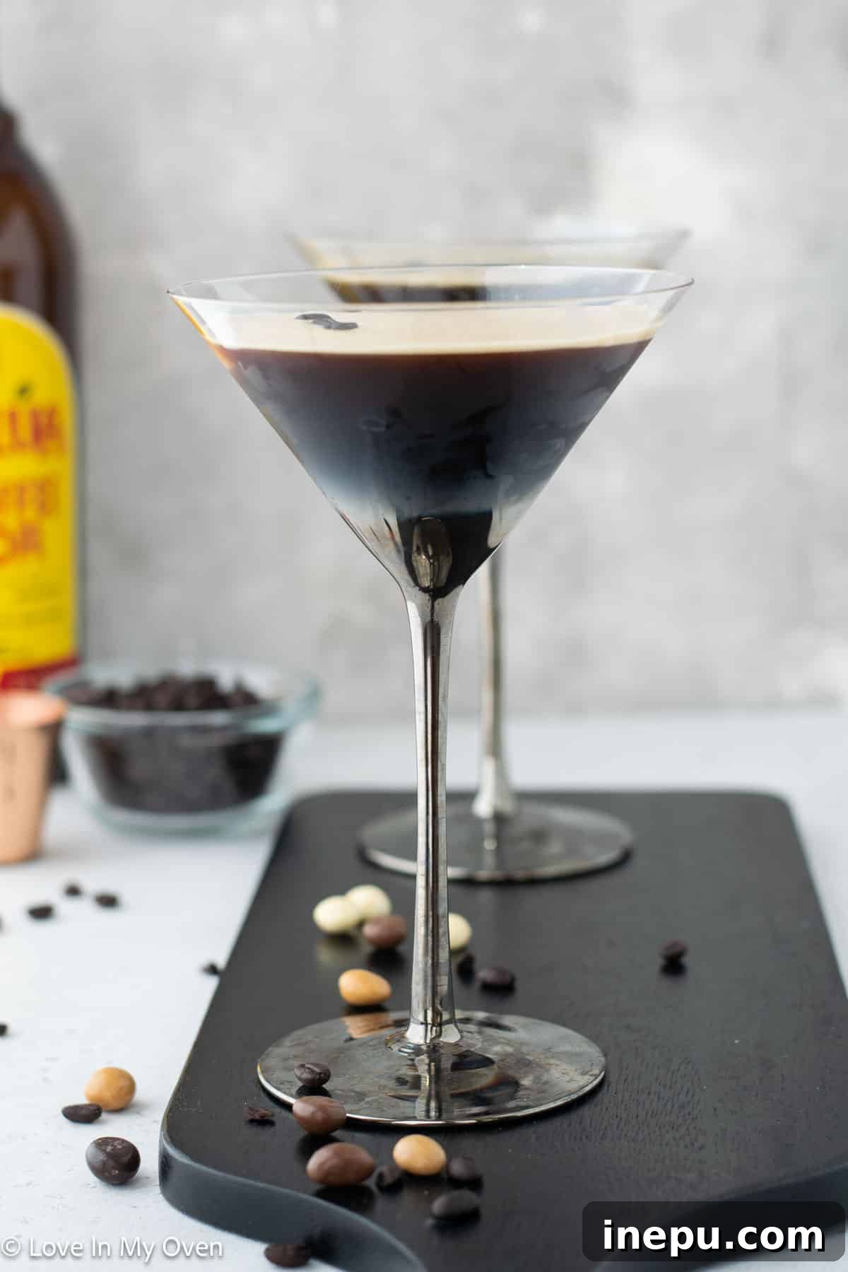 A stunning array of vodka espresso martinis, each perfectly garnished with espresso beans and a creamy foam, ready to be served at a gathering.