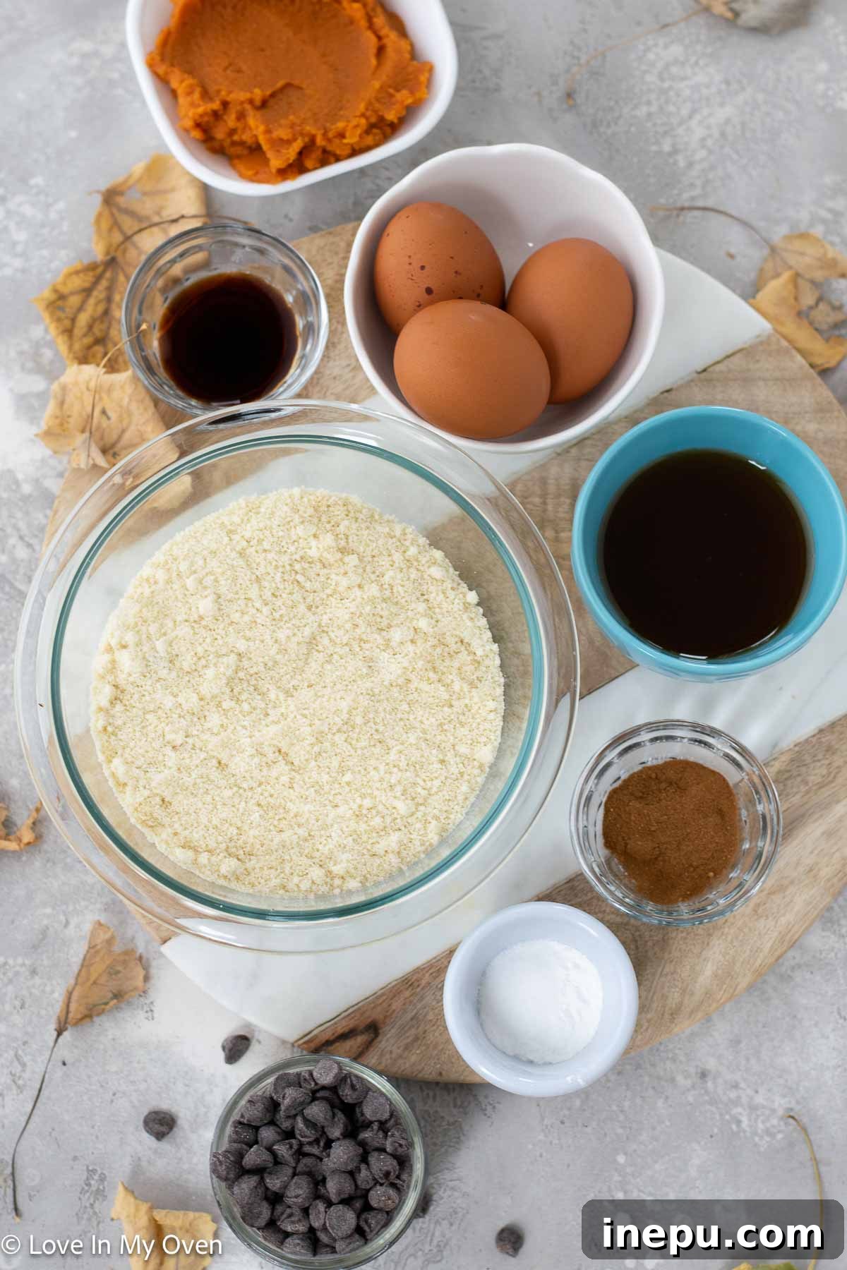 Bowl of wet ingredients for pumpkin muffins, including pumpkin puree, eggs, maple syrup, and vanilla extract.