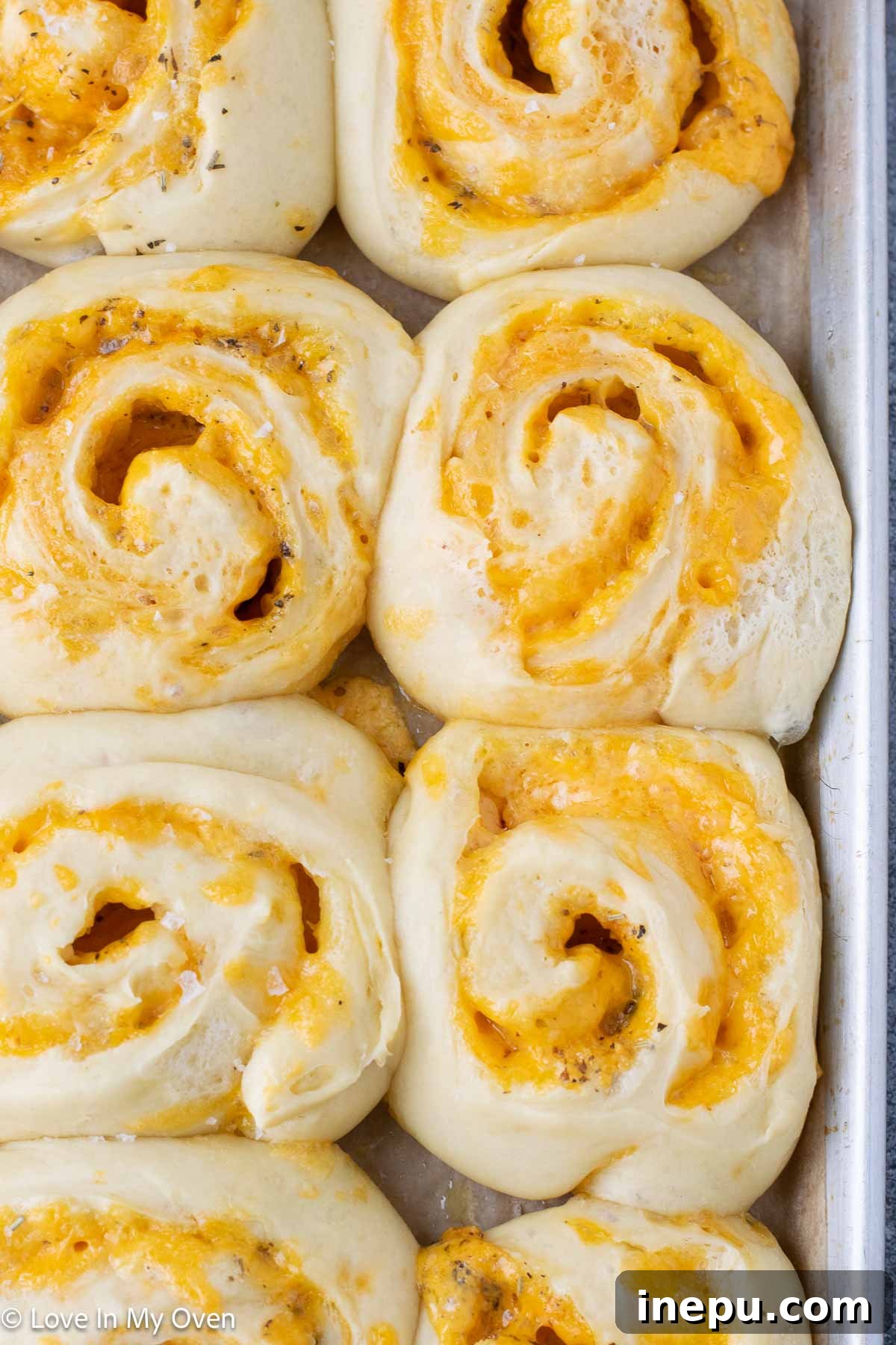golden brown, soft homemade cheese rolls on a baking sheet, ready to be enjoyed