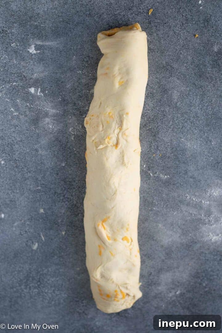 spreading butter and cheese on rolled dough
