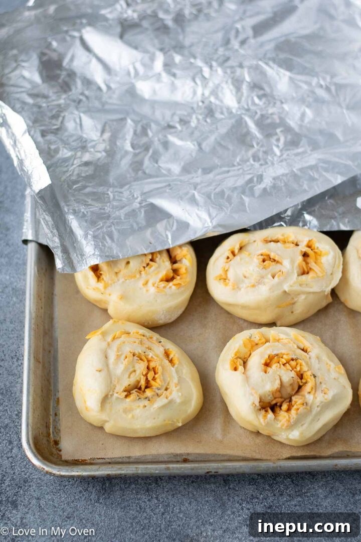 rolled dough log being cut into individual cheese rolls