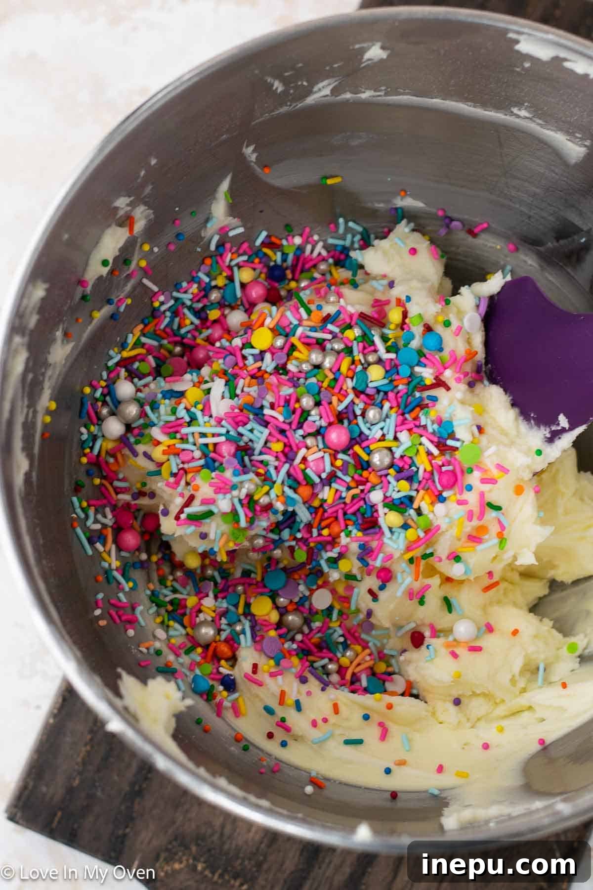 Sweet Stacks 8 Freshly made vanilla sprinkle buttercream in a mixing bowl.