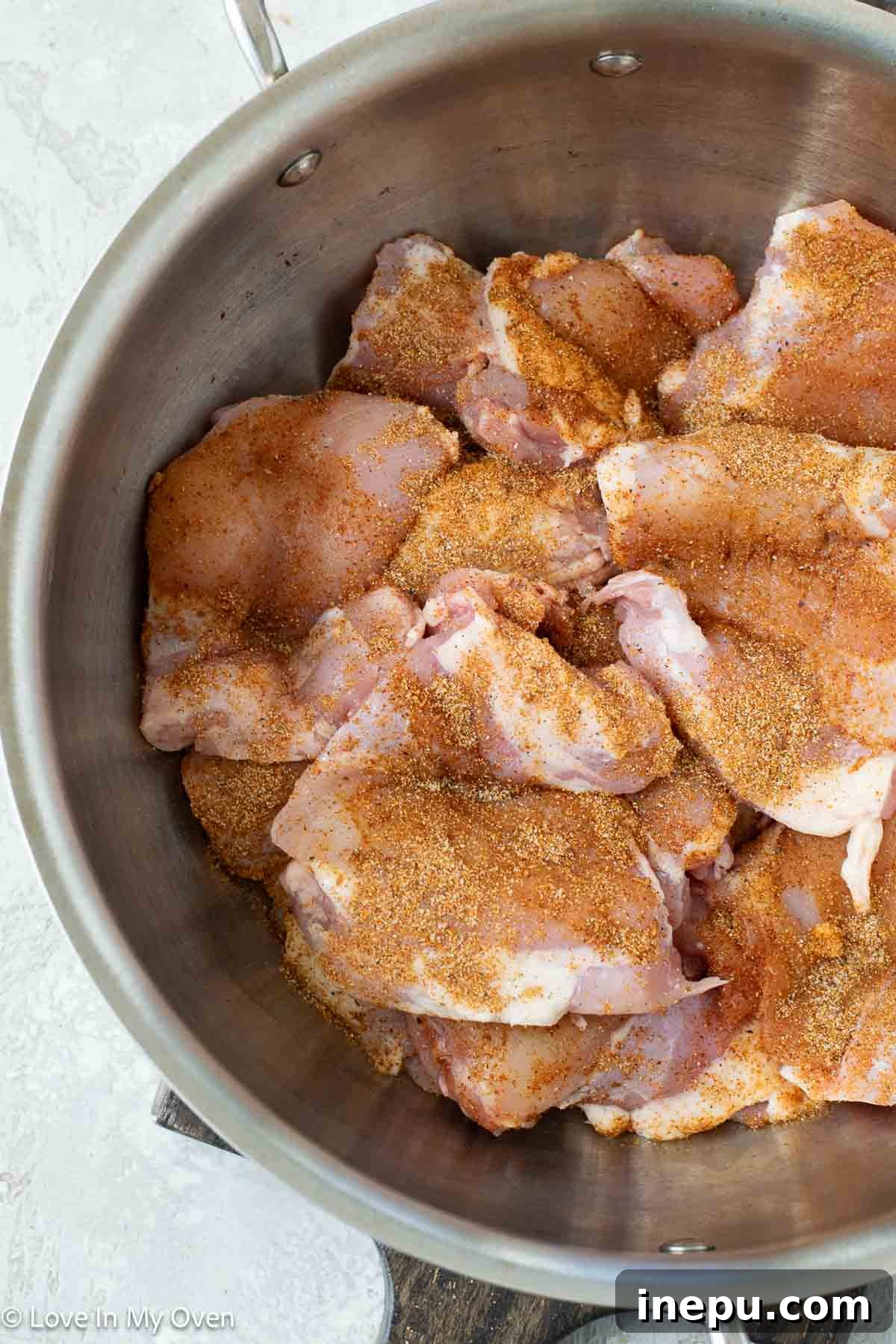 Shredding chicken with two forks on a cutting board