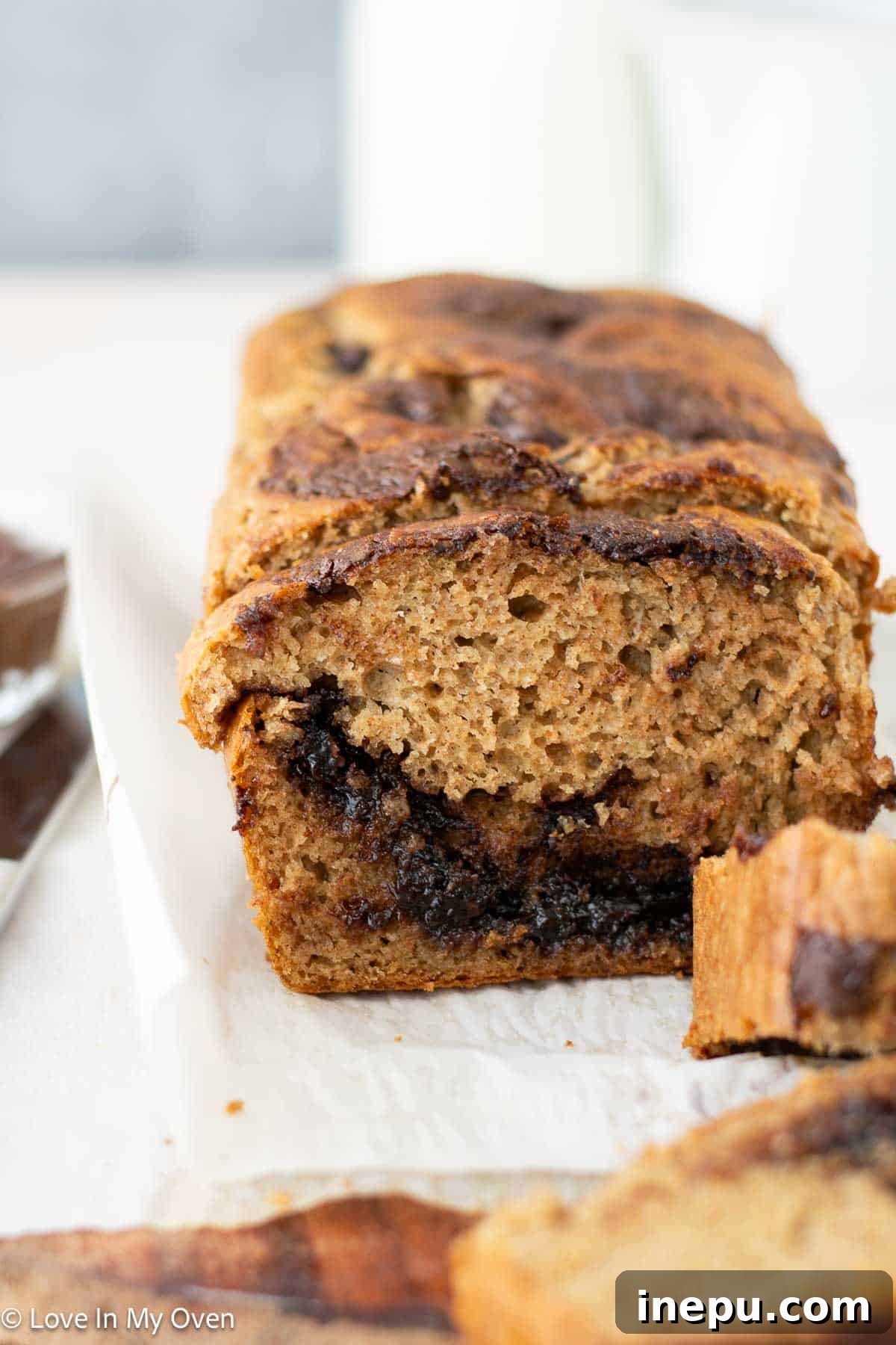 A beautiful slice of Nutella Swirl Banana Bread, showcasing the moist texture and hazelnut spread swirls.