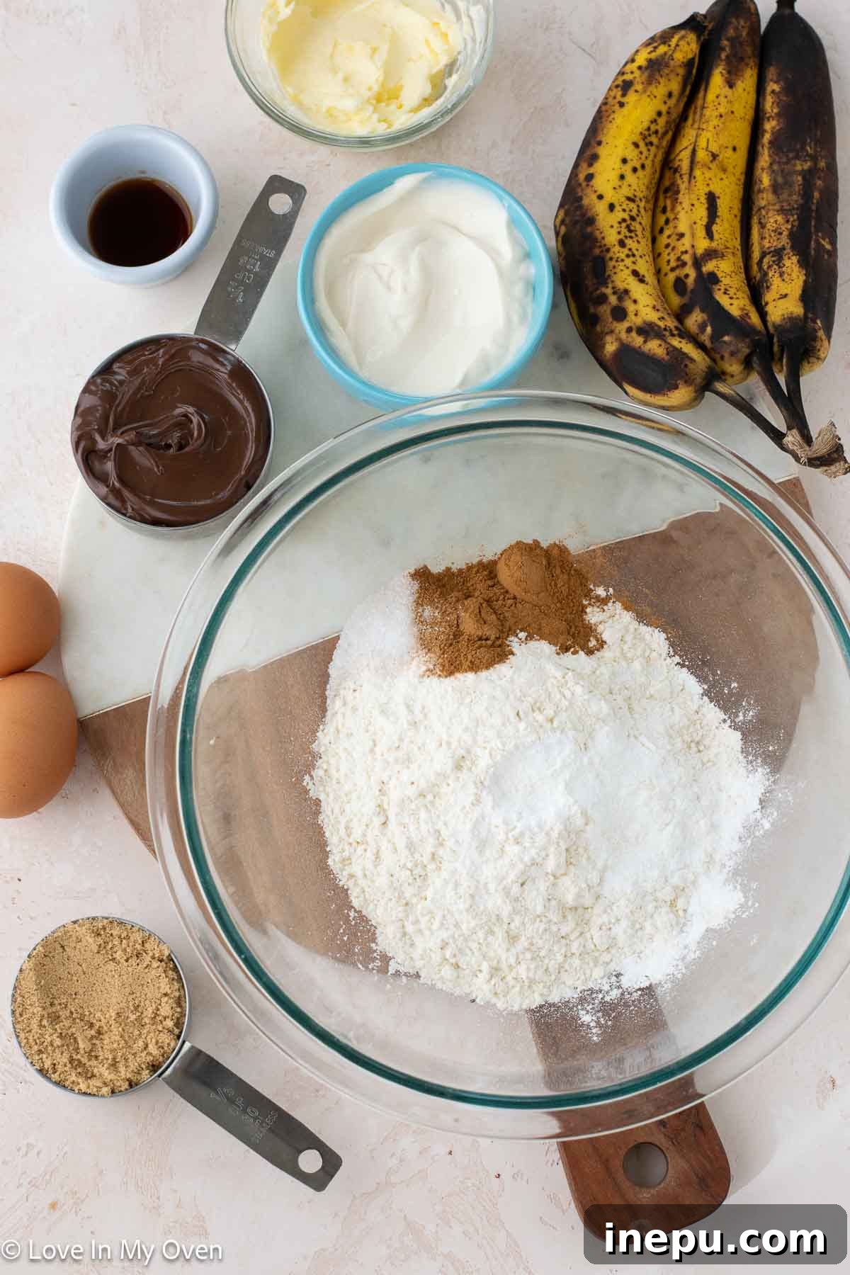 Array of ingredients for baking Nutella banana bread, including ripe bananas and baking essentials.