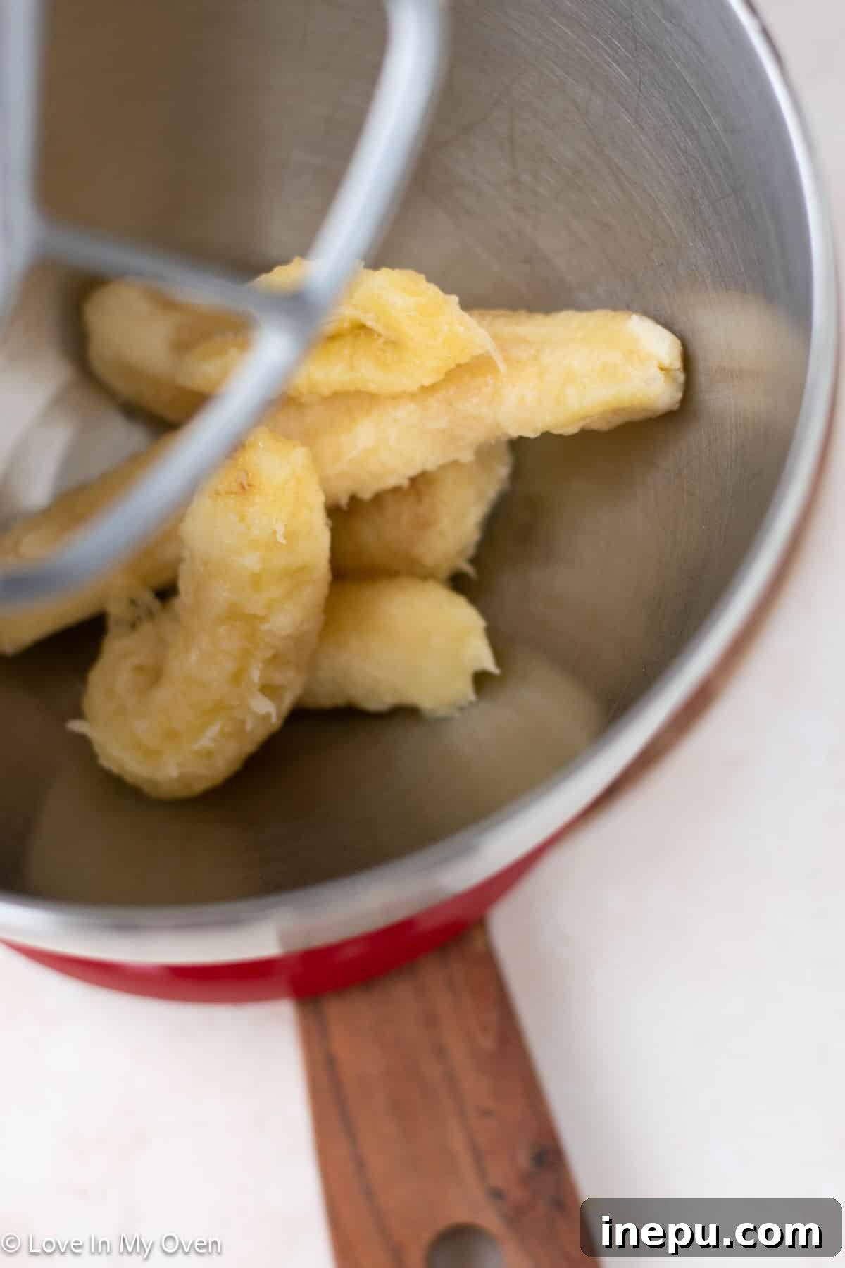 Preparing banana bread batter in a mixing bowl.