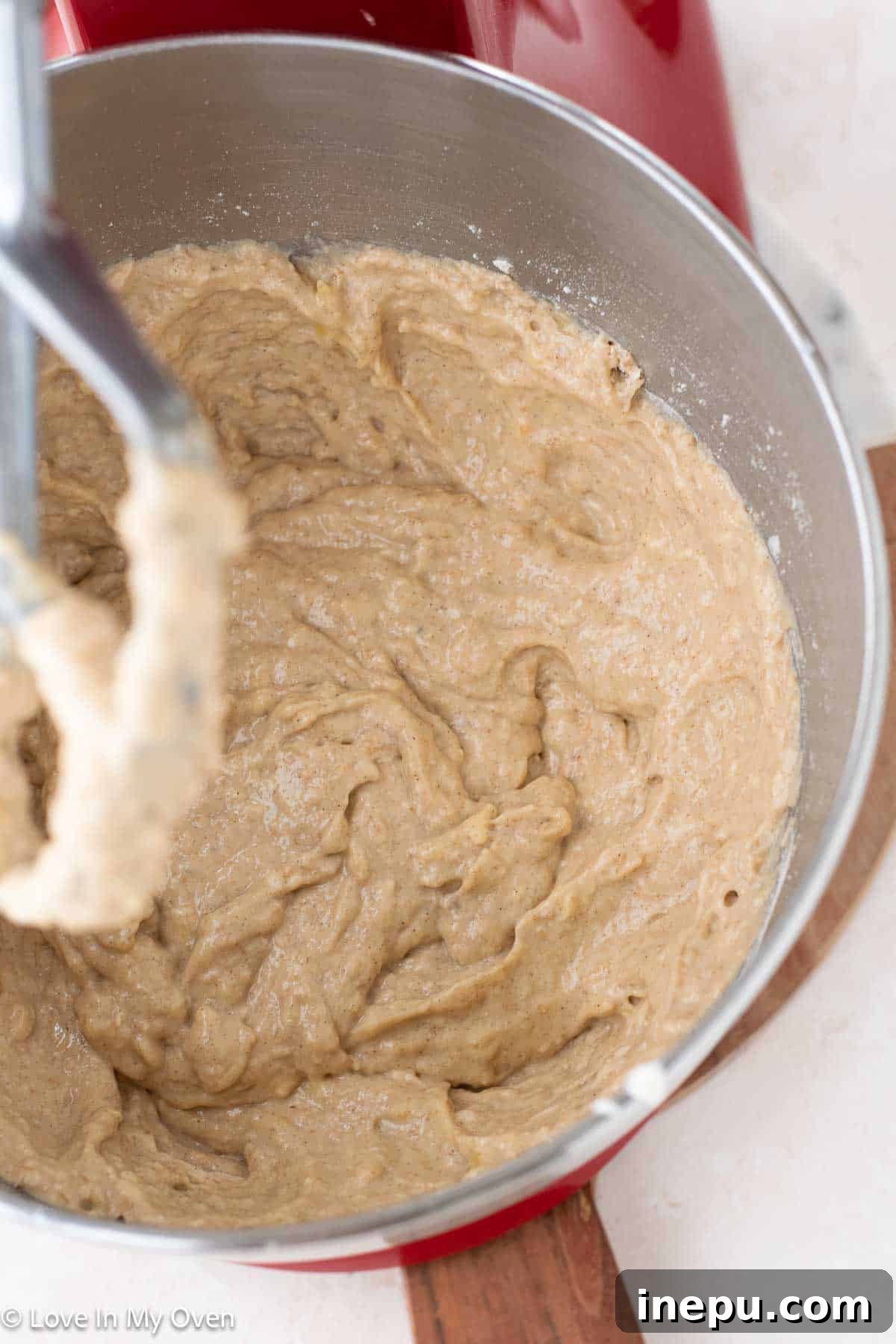 Nutella being spooned into banana bread batter for swirling.