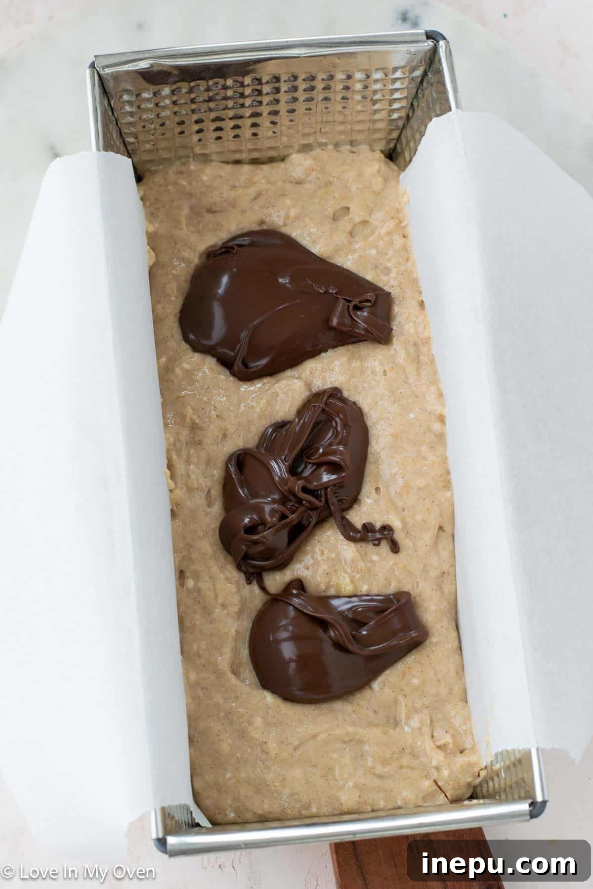 A freshly baked loaf of Nutella banana bread cooling on a wire rack.
