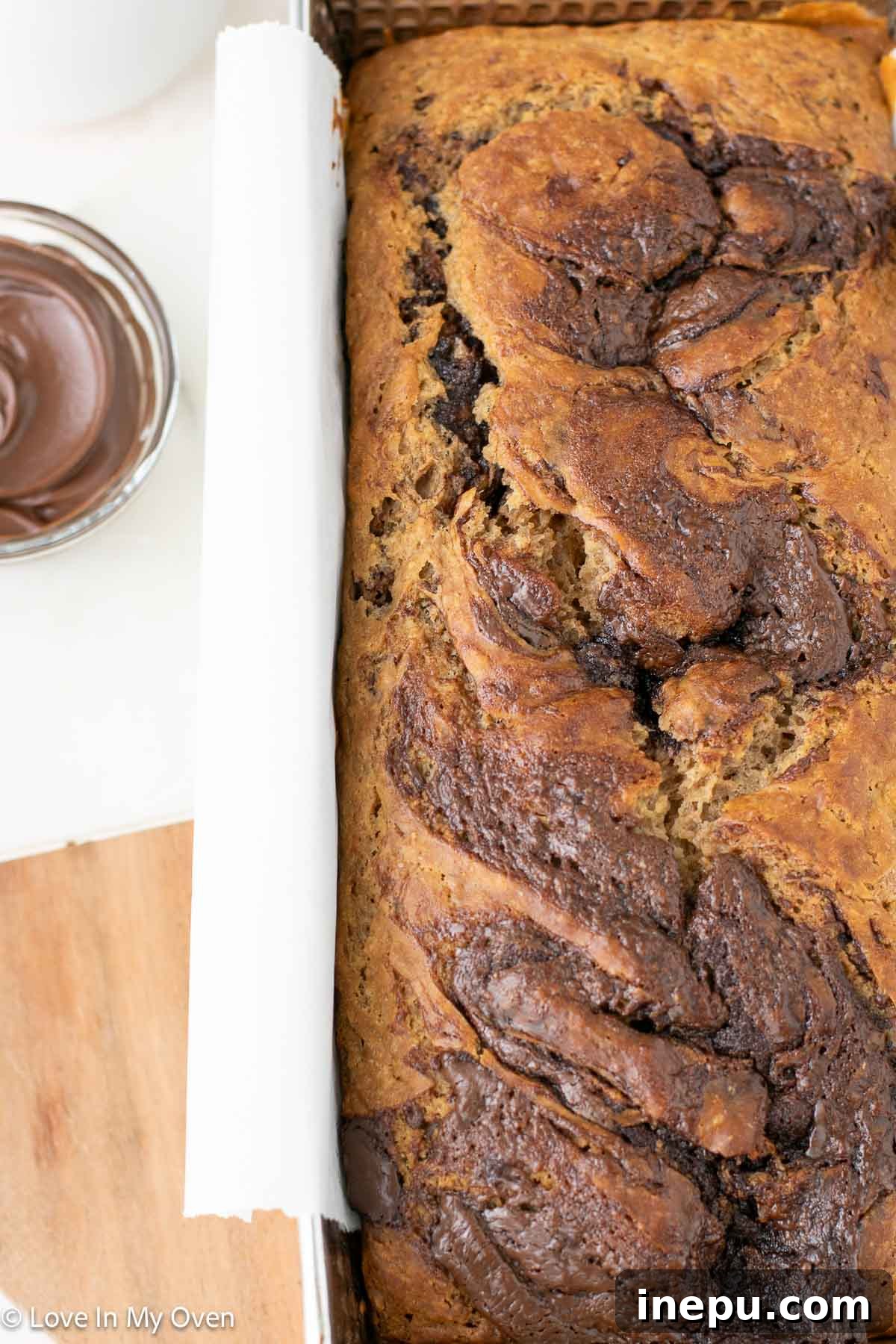 A beautifully golden-brown Nutella banana bread, fresh from the oven and ready to be enjoyed.