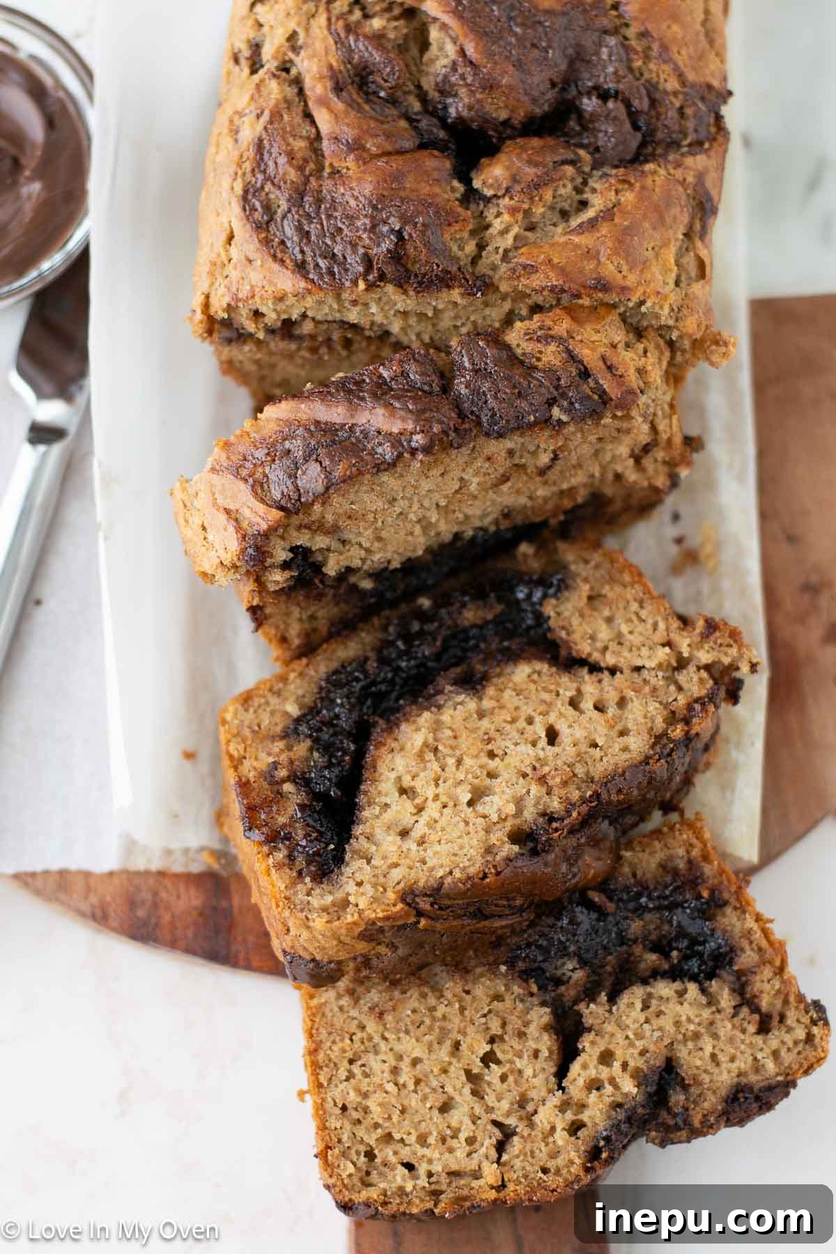 Close-up of a slice of Nutella banana bread, showing the luscious Nutella swirls and moist crumb.