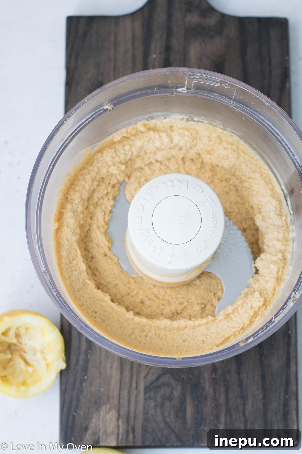 Golden Roasted Garlic Hummus 5 Close-up view of freshly blended creamy roasted garlic hummus in a food processor, ready to be served