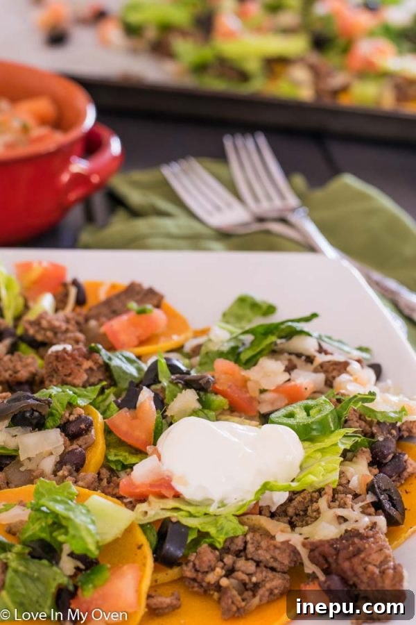 Butternachos 6 Vertical shot of butternut squash nachos, showing layers of toppings.