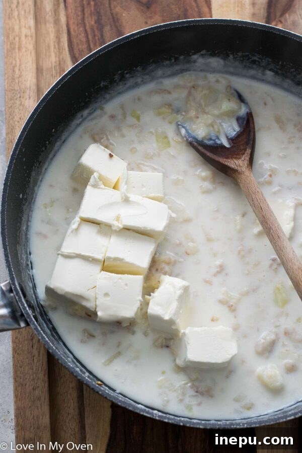 Cream cheese melting into the sauce for vegetable casserole