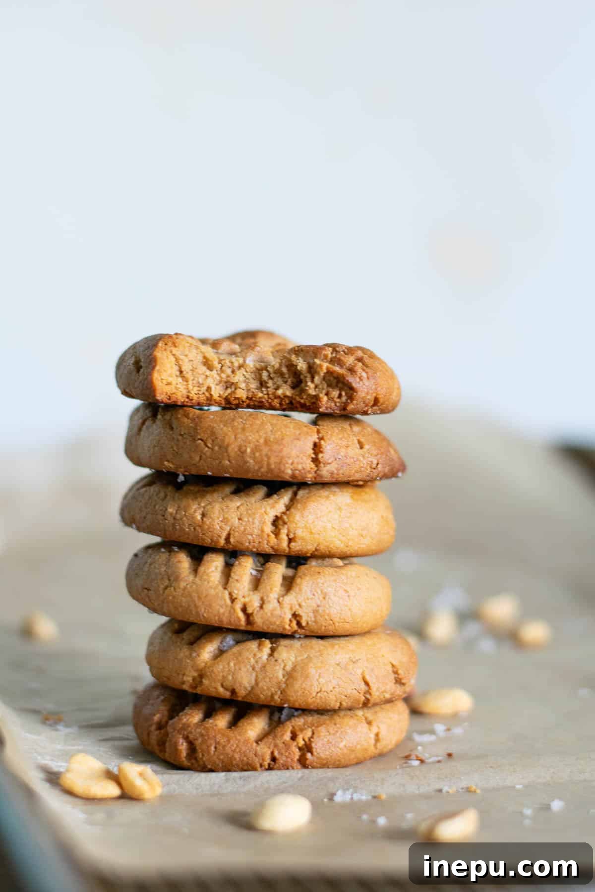 Hand holding a 3-ingredient gluten-free peanut butter cookie with a bite taken out