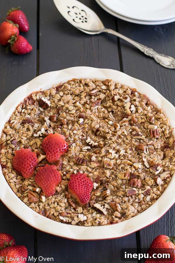 Strawberry Streusel Baked Oats 5 A square slice of strawberry streusel baked oatmeal on a white plate, ready to be served