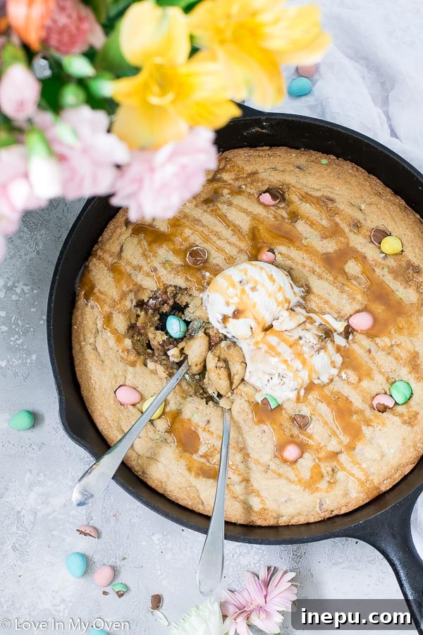 Close-up of a giant mini egg skillet cookie, showing gooey center and chocolate chunks