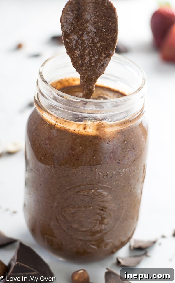 Close-up of homemade Notella in a jar, ready to be enjoyed with a spoon.