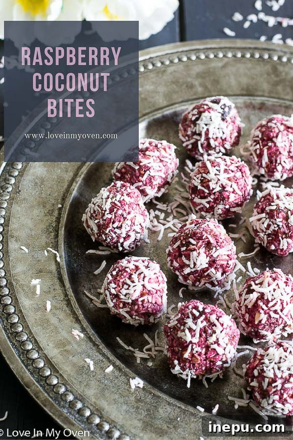 Vibrant raspberry coconut bites arranged on a light surface, showcasing their natural pink color and shredded coconut coating.