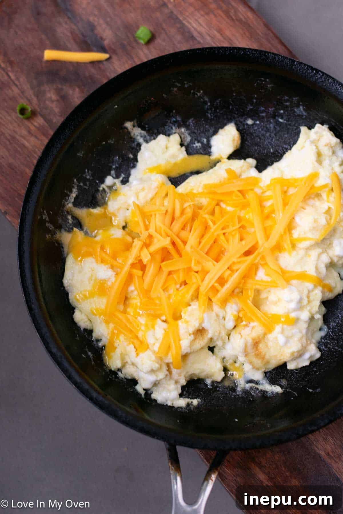 Protein-Packed Scramble 7 adding cheddar cheese to scrambled eggs