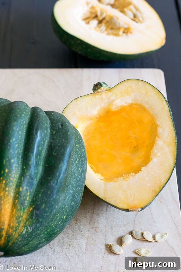 An acorn squash cut in half with seeds removed, ready for roasting